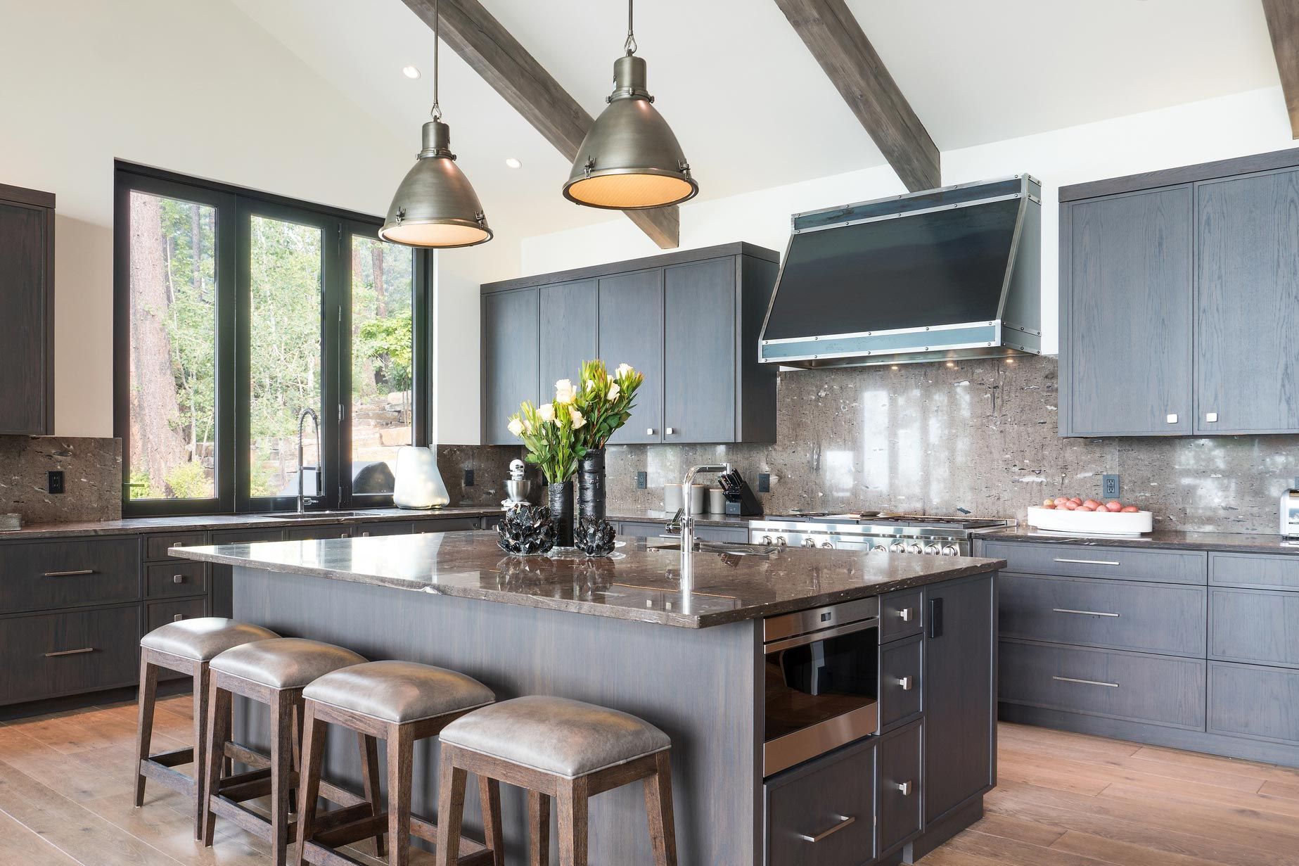 A kitchen with a large island in the middle and stools.
