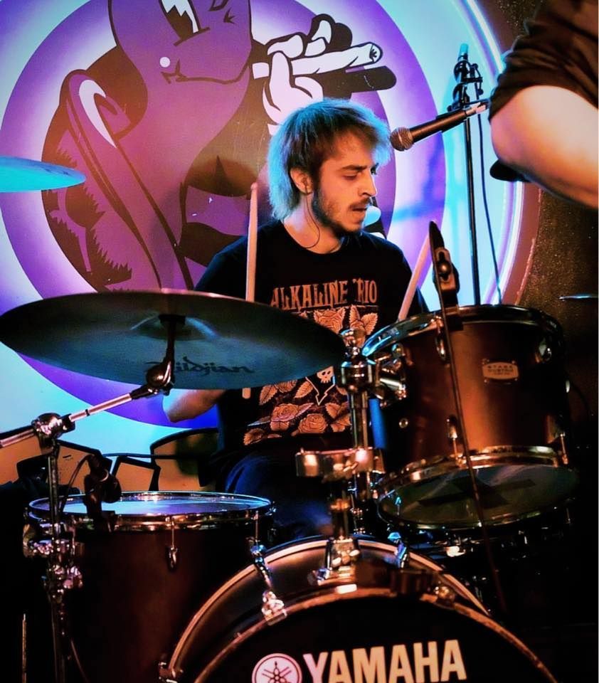 A man playing drums in front of a yamaha drum set