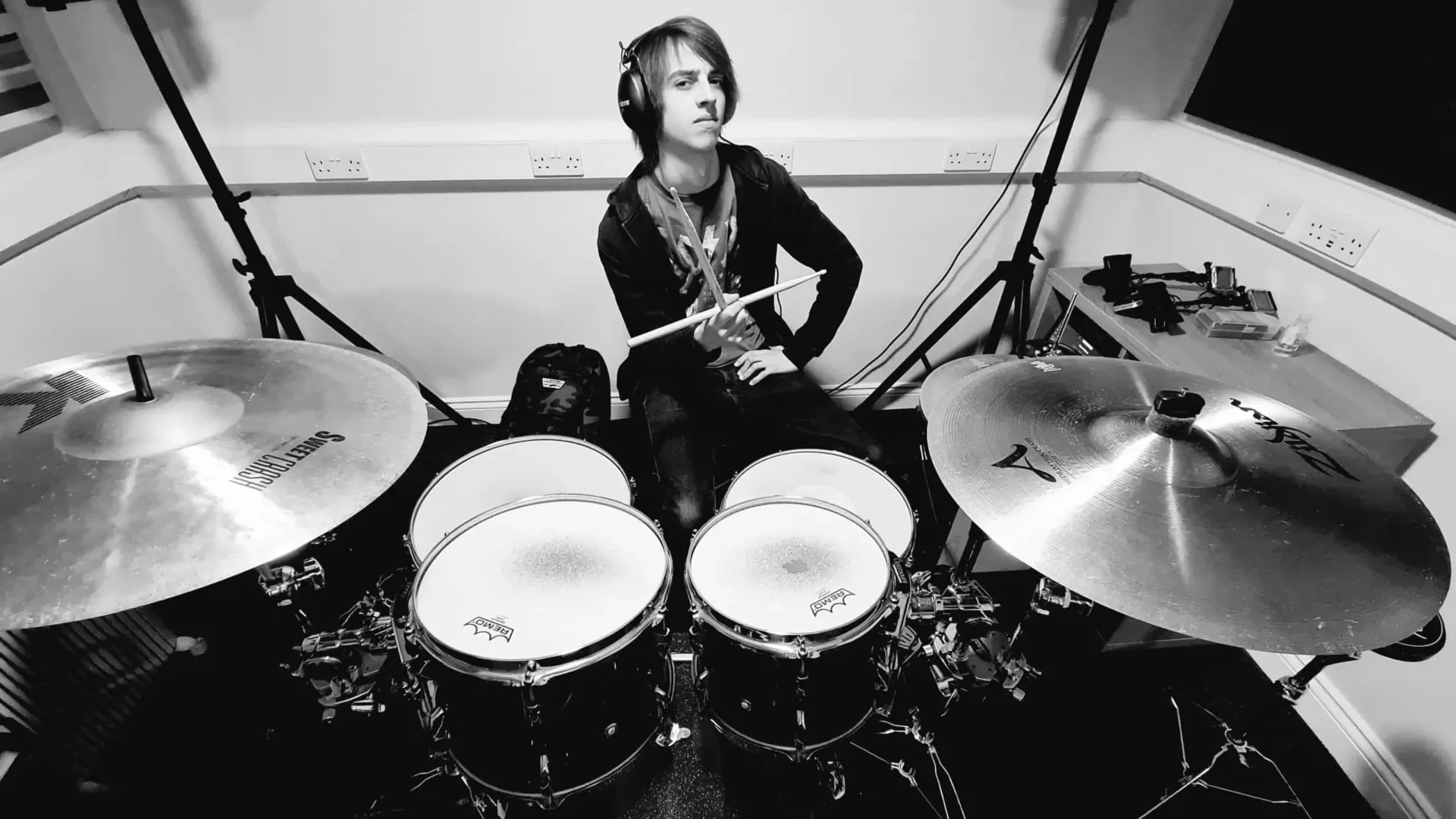 A man is playing drums in a black and white photo