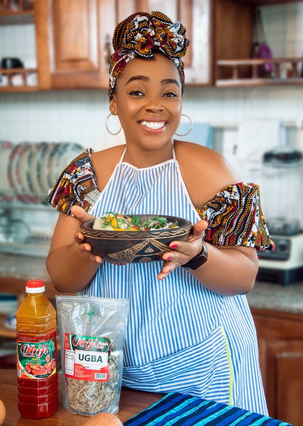 A woman is holding a bowl of food in her hands in a kitchen.