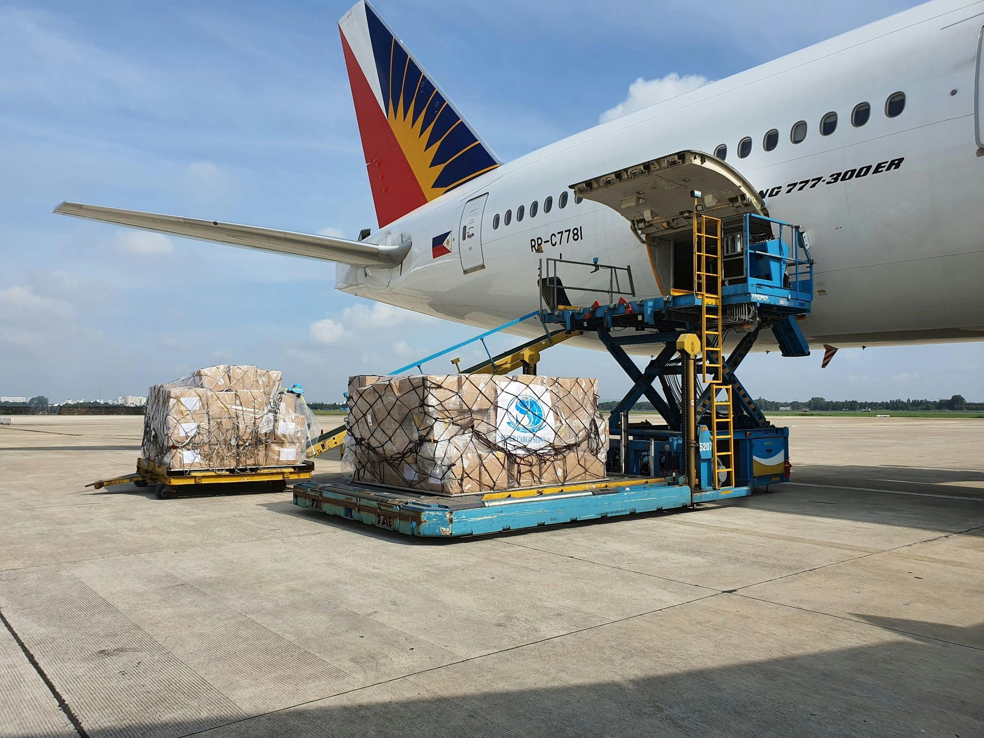 A plane is being loaded with cargo on the tarmac