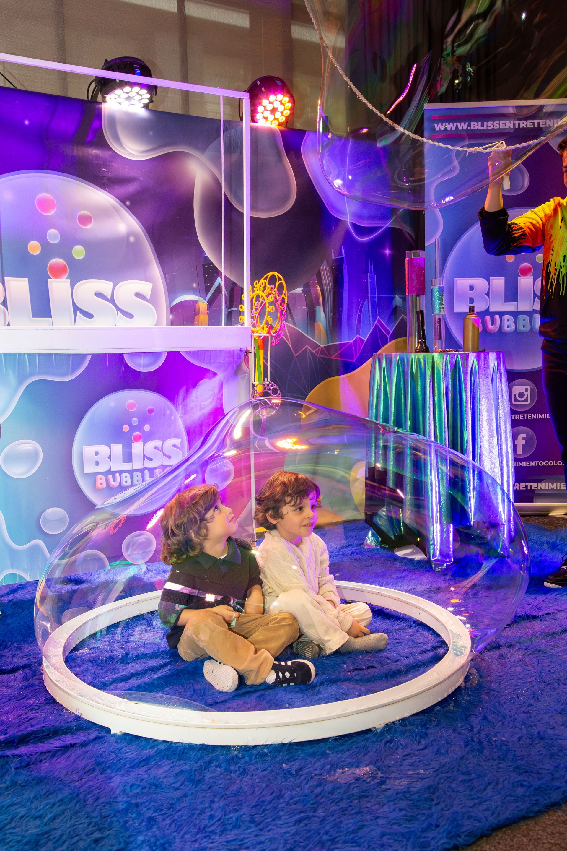 Dos niños dentro de una gran burbuja en un evento 