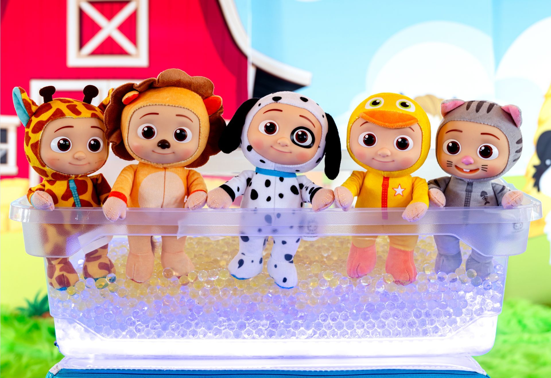 Un grupo de animales de peluche están sentados en un recipiente de plástico lleno de agua.