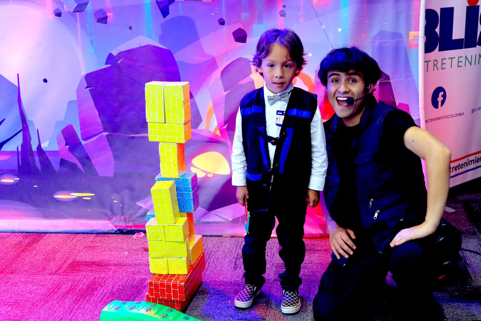 Un hombre y un niño están de pie junto a una pila de bloques.