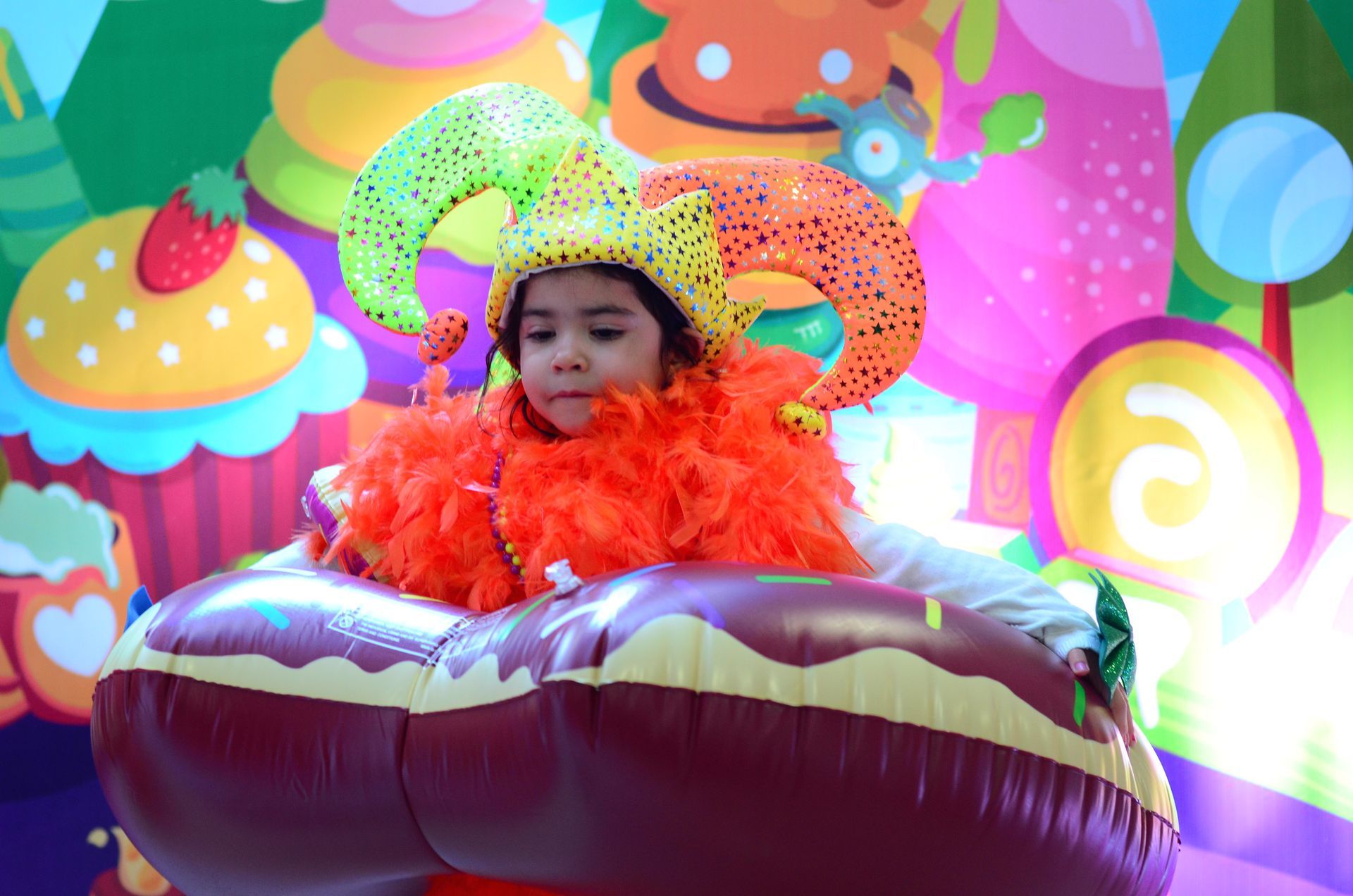 Una niña está sentada en un donut inflable.