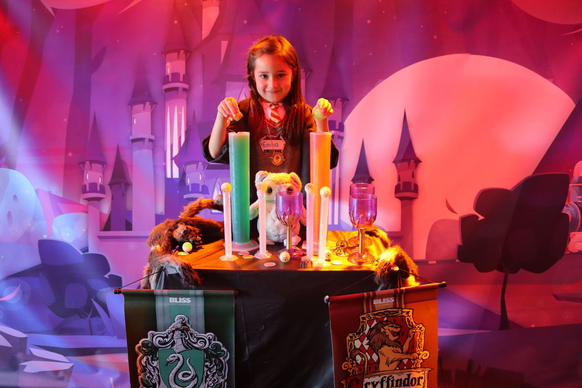 Una niña está parada frente a una mesa con un castillo al fondo.