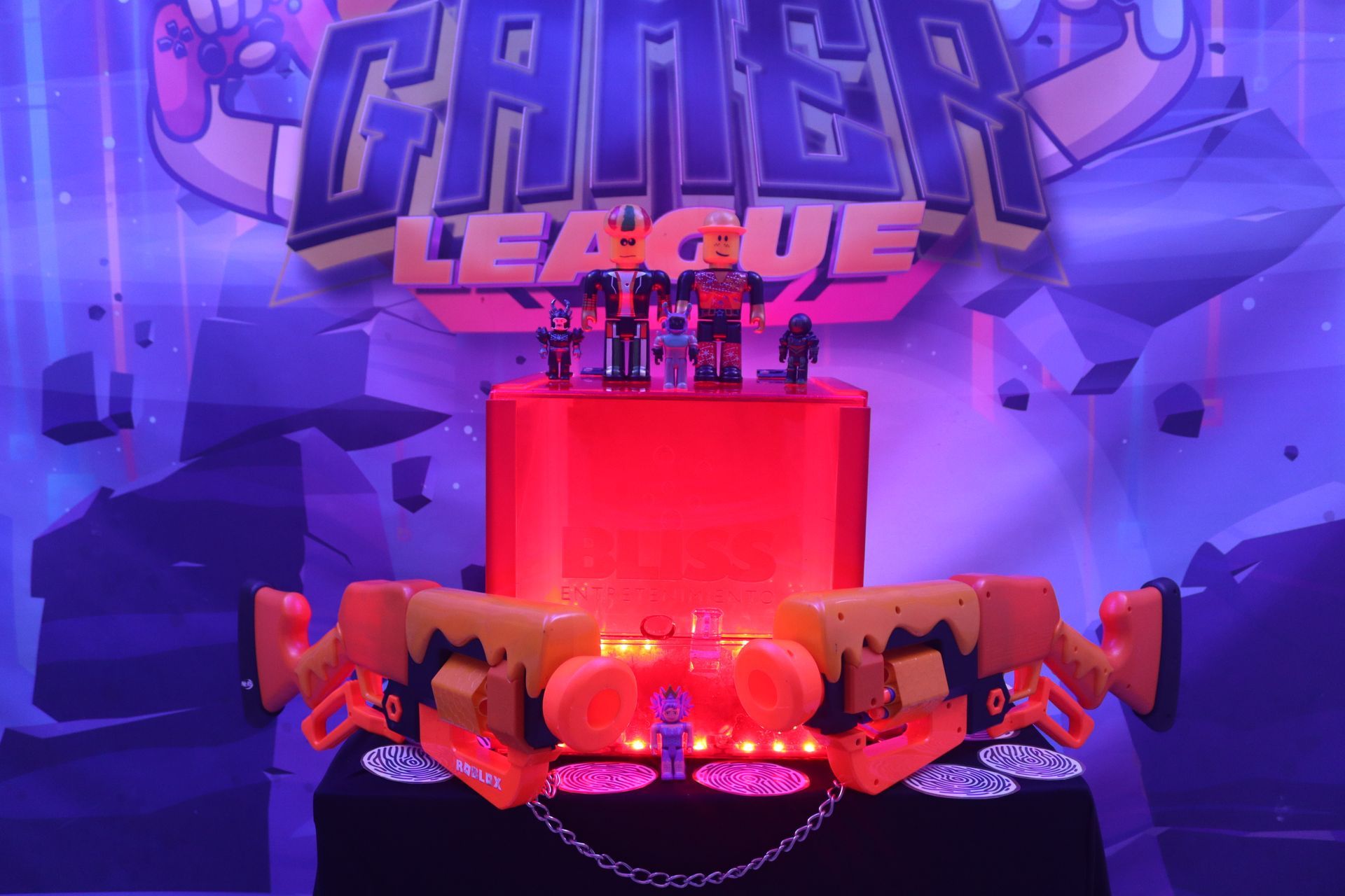 Un pastel rojo se encuentra sobre una mesa frente a un cartel de una liga de jugadores.