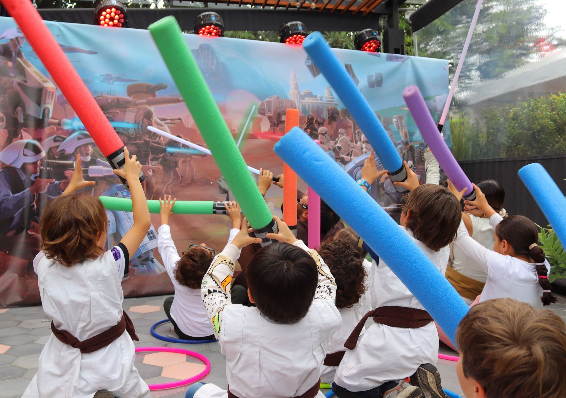 Un grupo de niños está jugando con espadas de espuma.