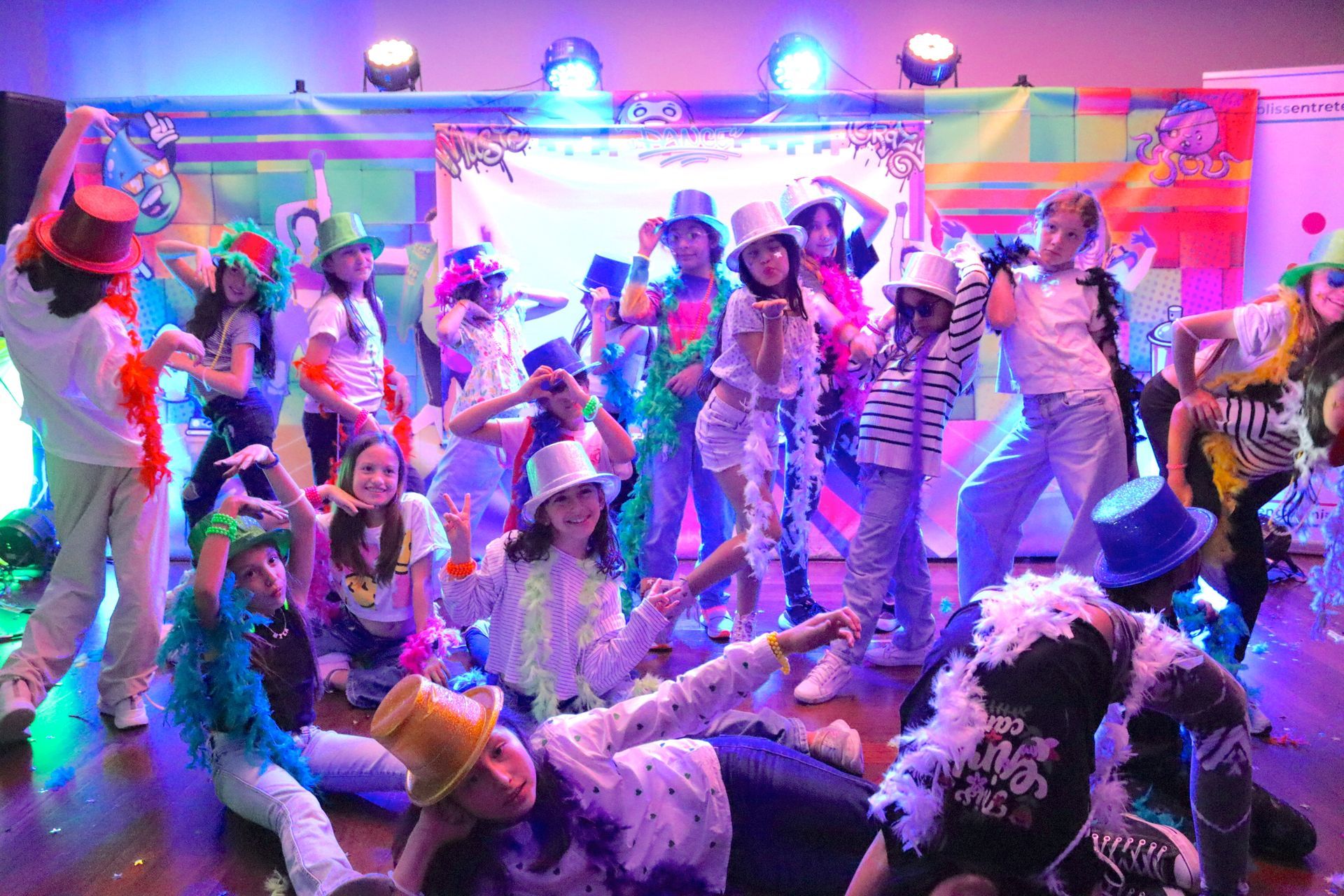 Un grupo de niños está bailando en un escenario en una fiesta.