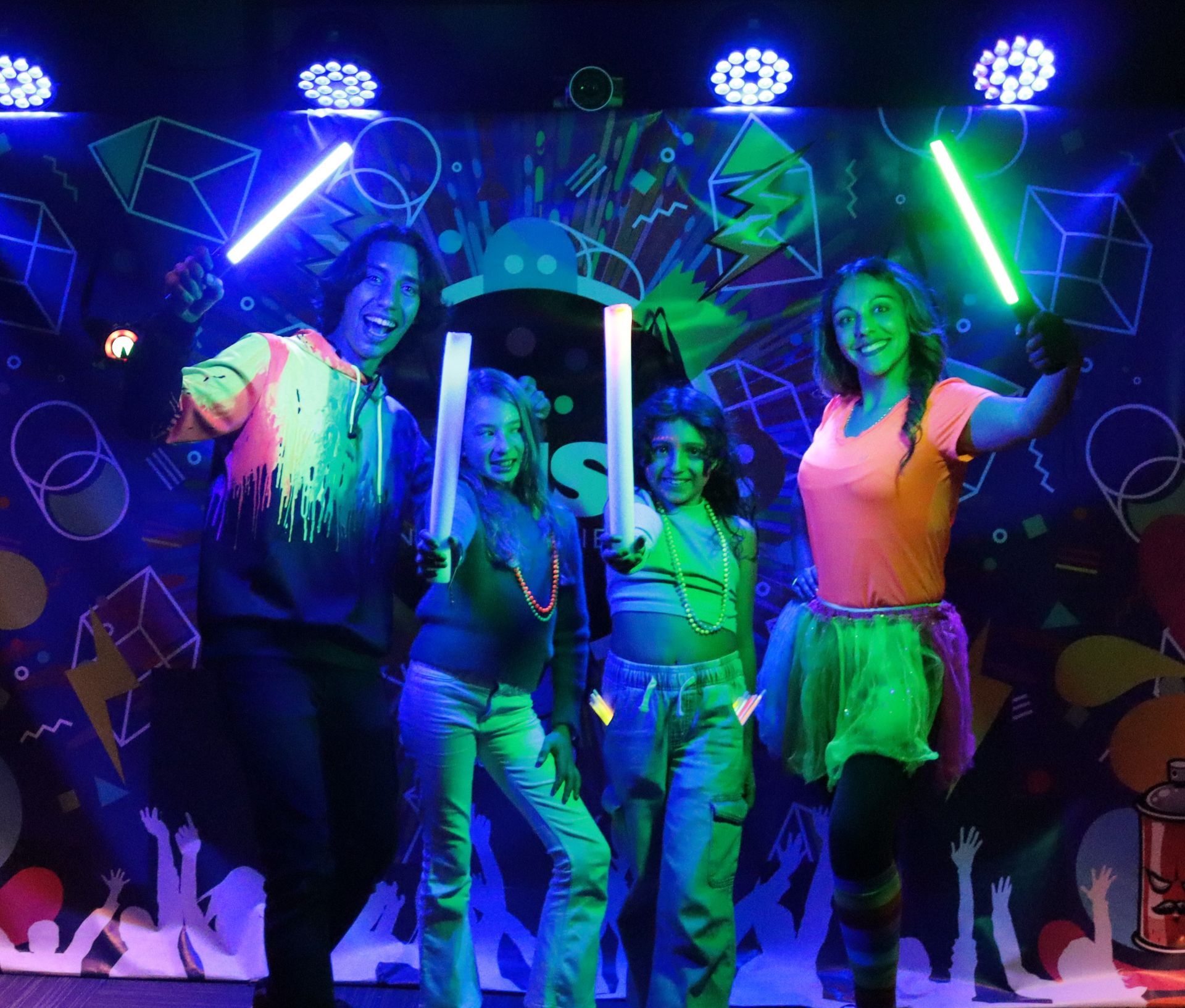 Un grupo de personas sostienen sables de luz que brillan en la oscuridad.