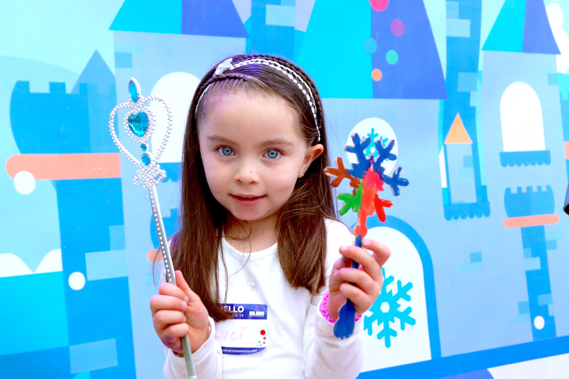 Una niña sostiene una varita frente a un castillo.