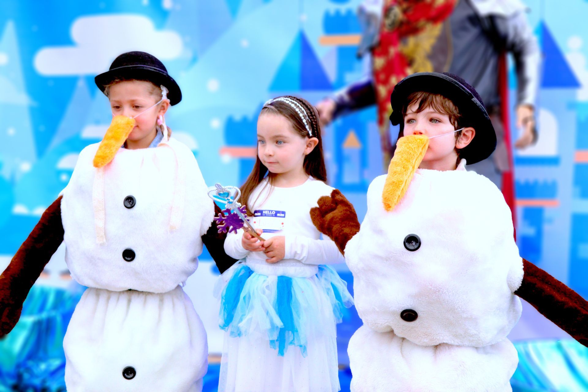 Tres niños vestidos como muñecos de nieve están parados uno al lado del otro.
