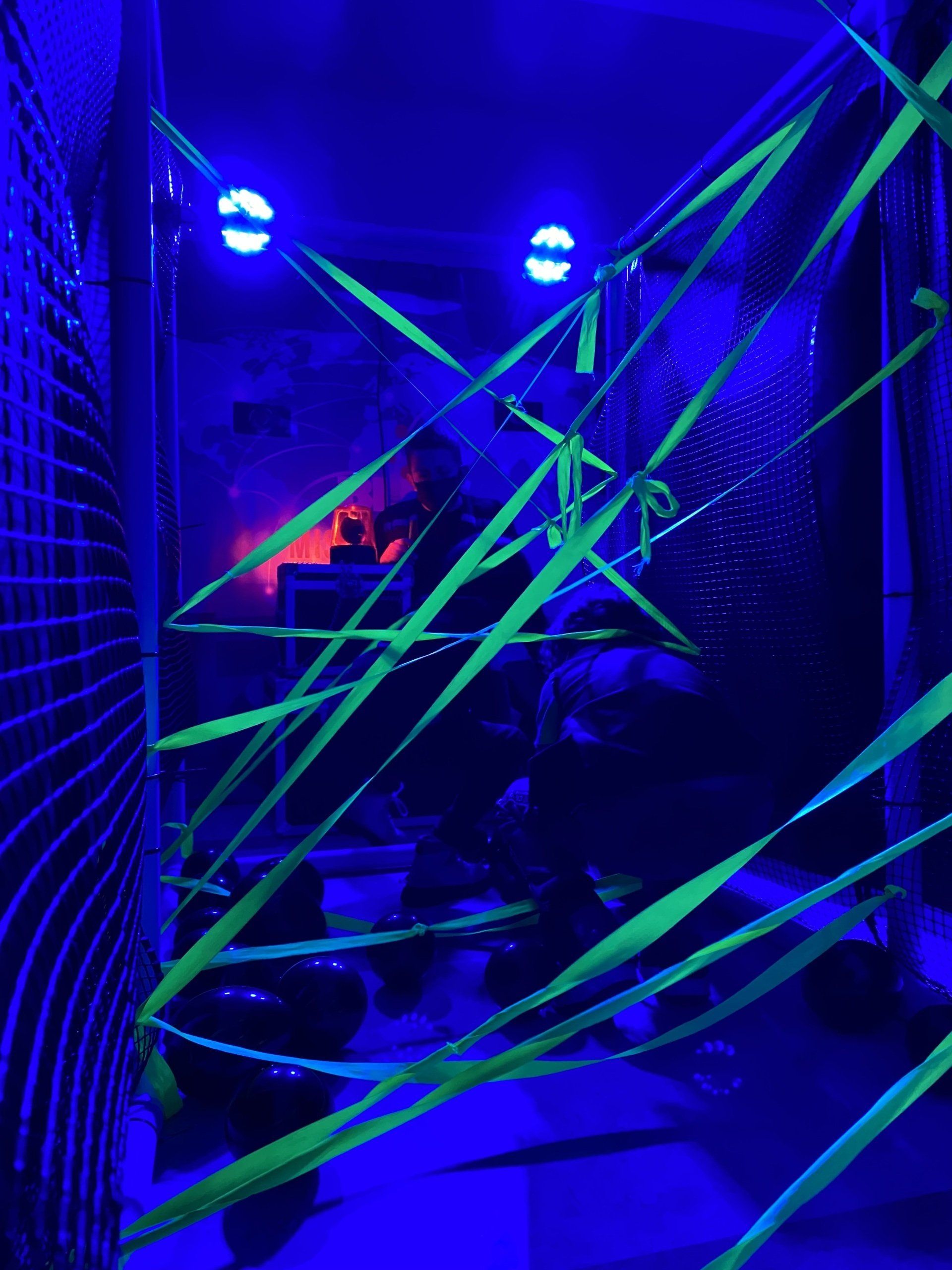 Una habitación decorada con cinta y luces que brillan en la oscuridad.