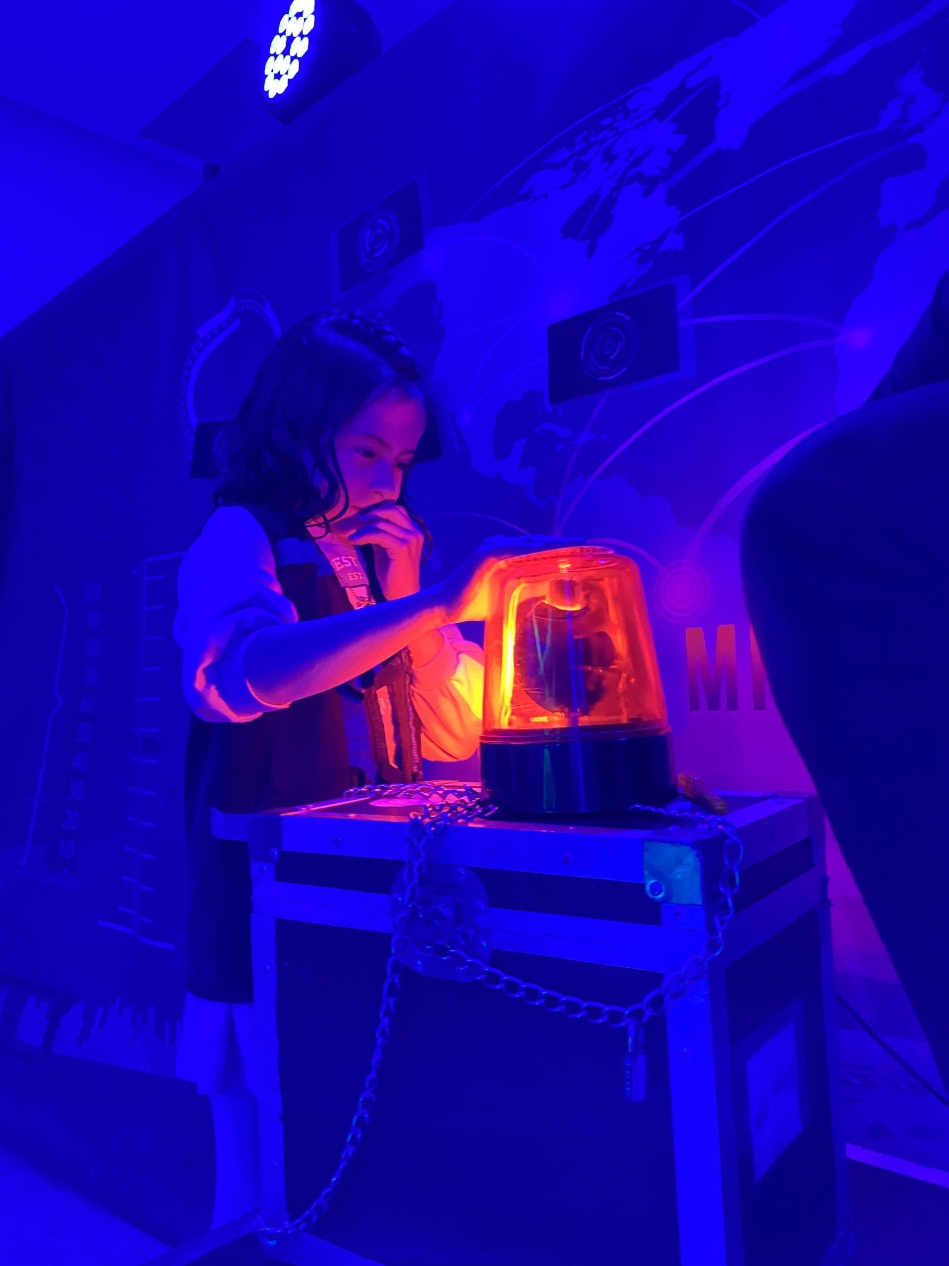 Una niña está parada frente a una luz azul.