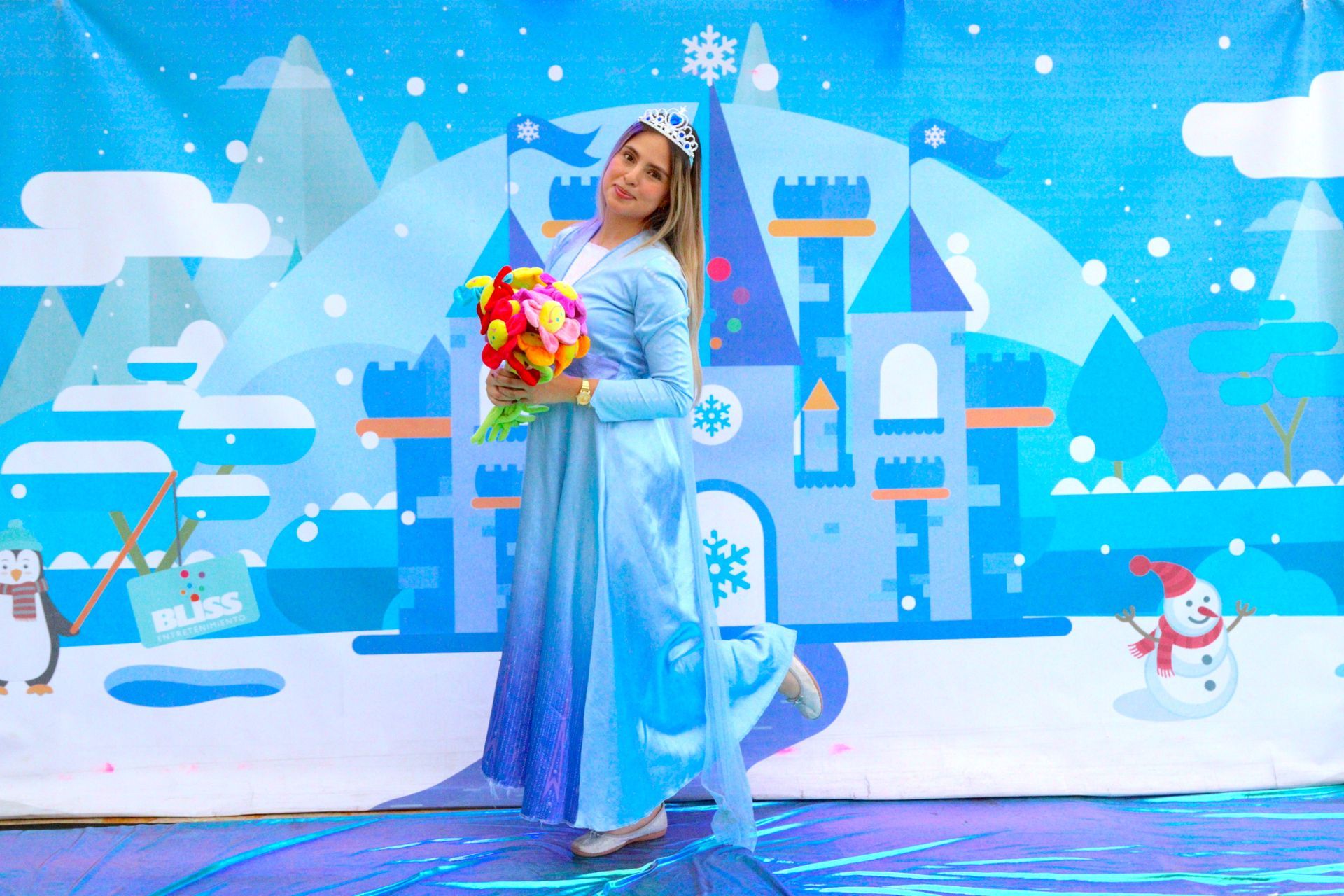 Una mujer con un vestido azul sostiene un ramo de flores frente a un castillo.