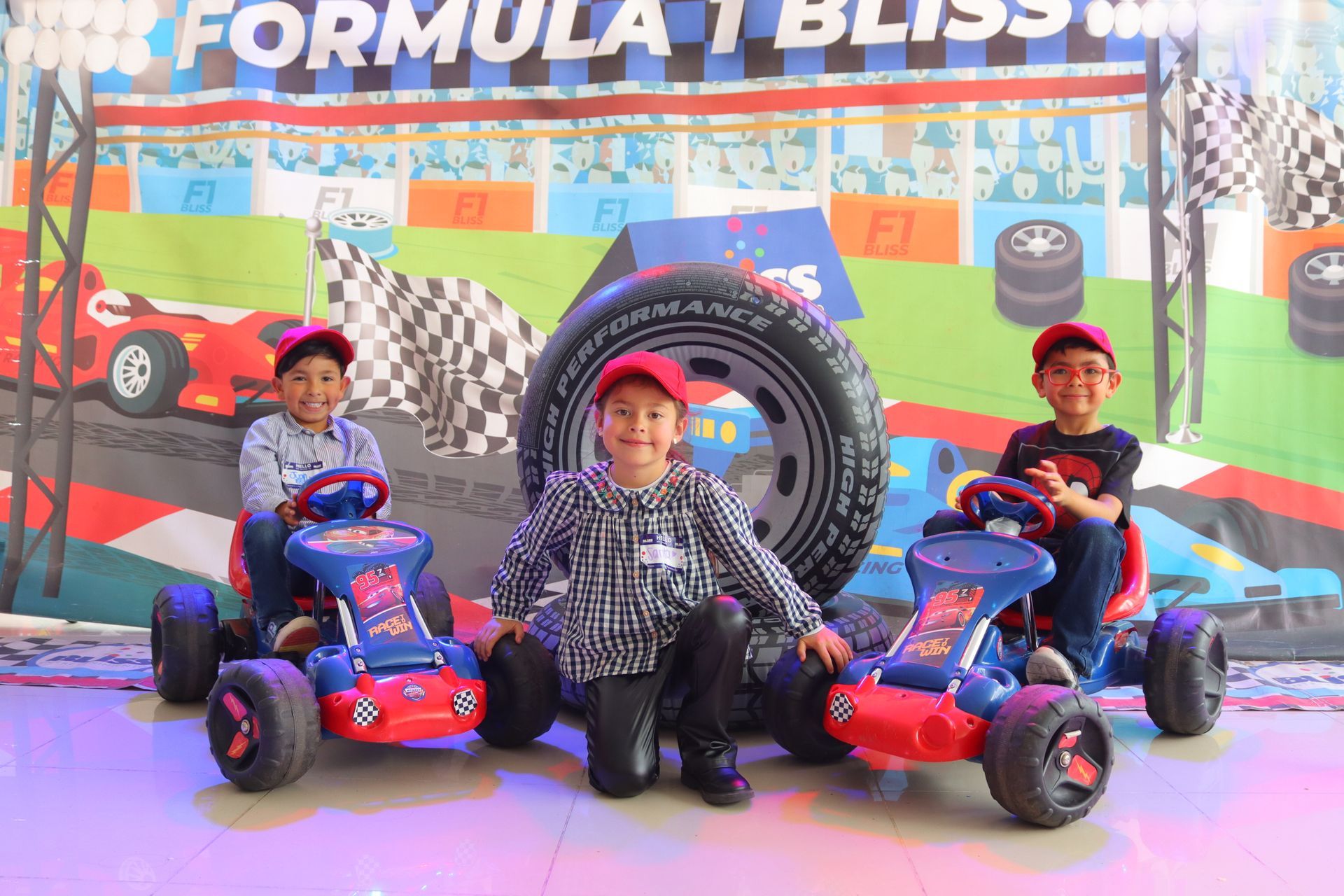 Tres jóvenes posan para una fotografía mientras están sentados en karts.