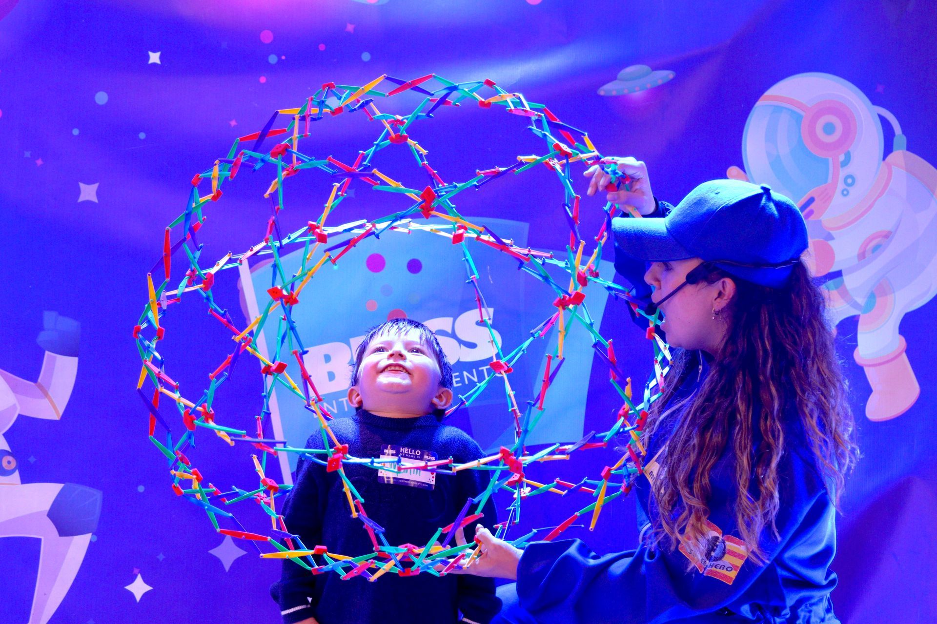 Una mujer y un niño están jugando con una pelota de colores en un escenario.
