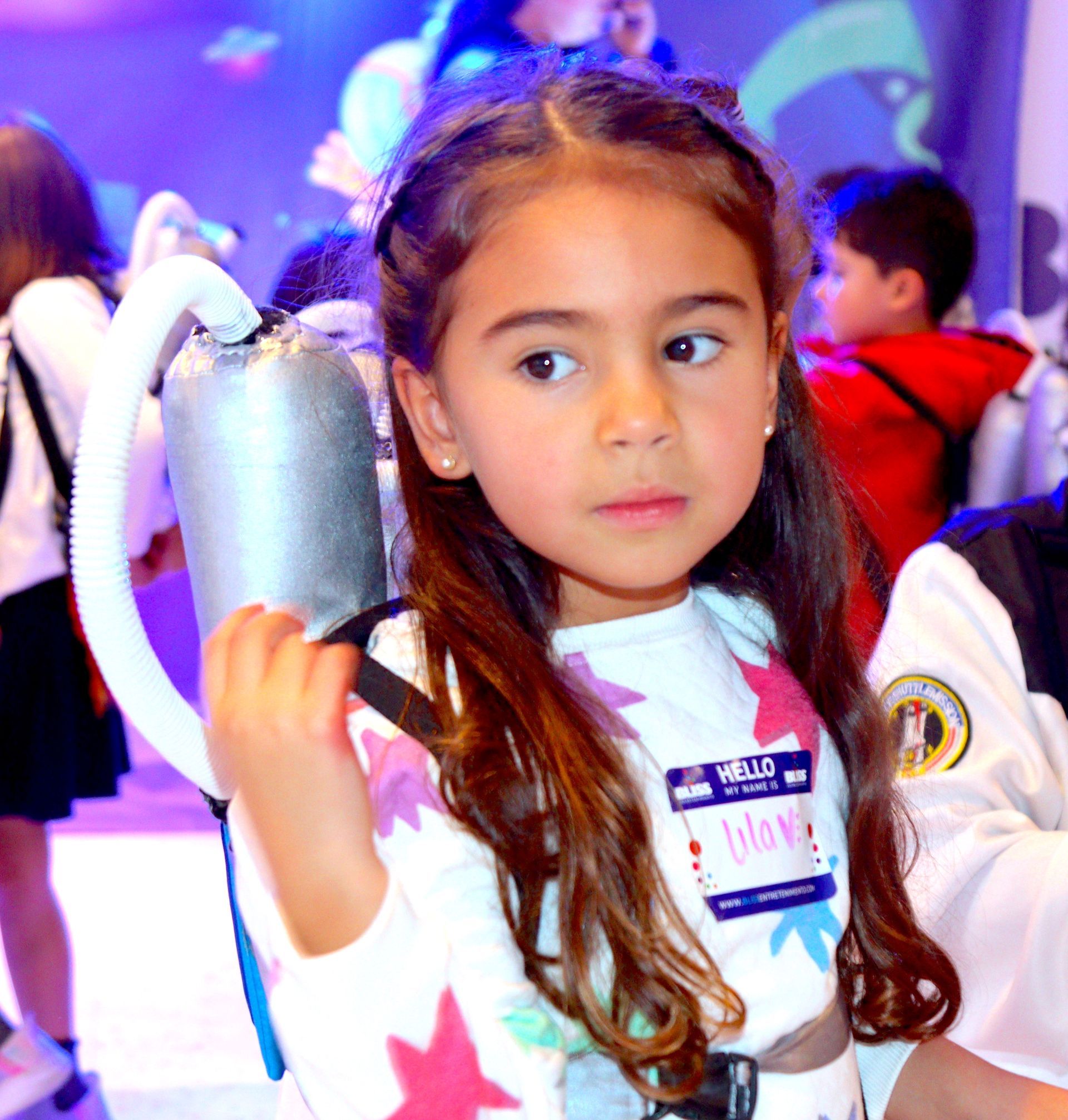 Una niña que lleva una etiqueta con el nombre 