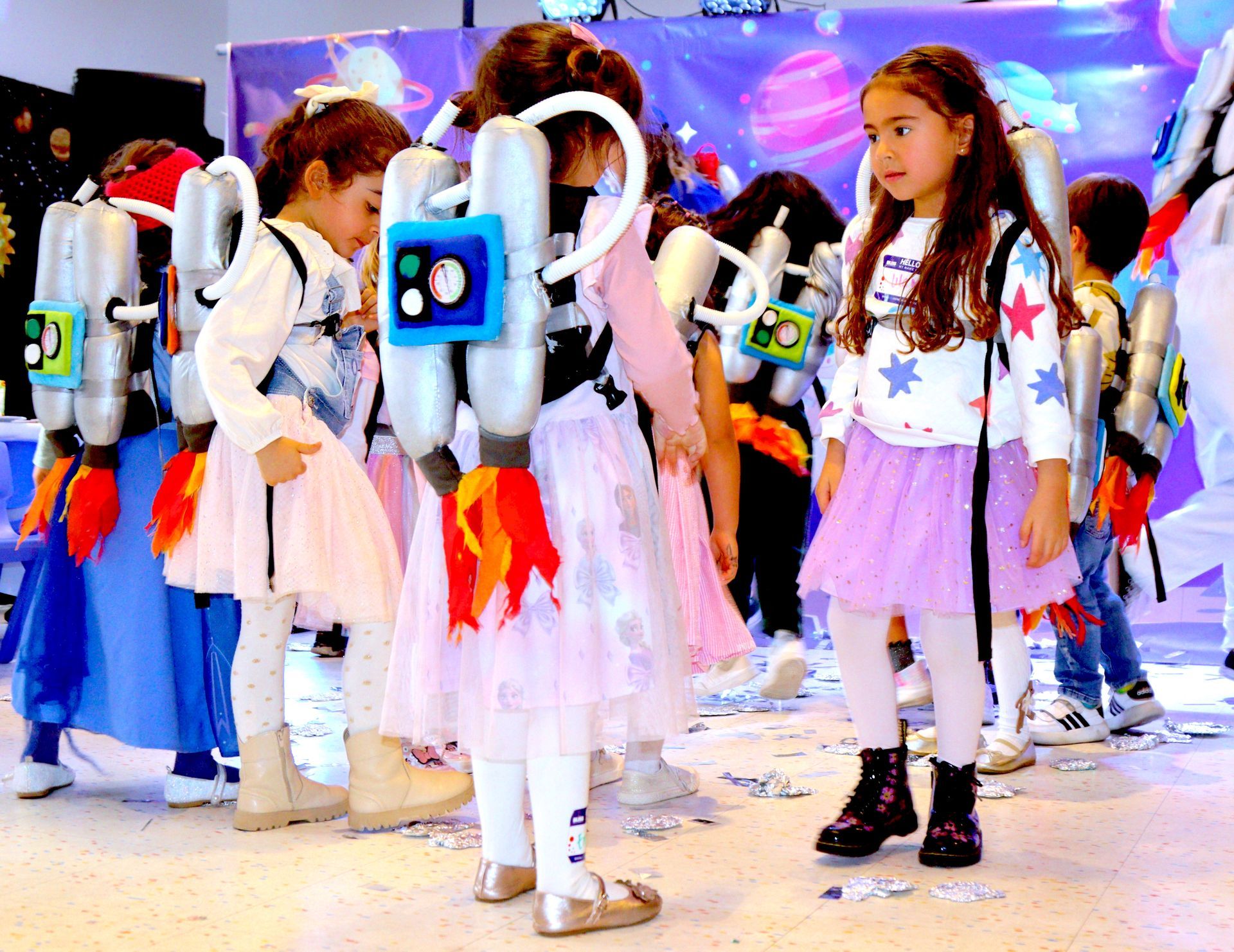 Un grupo de chicas jóvenes están vestidas con trajes espaciales.