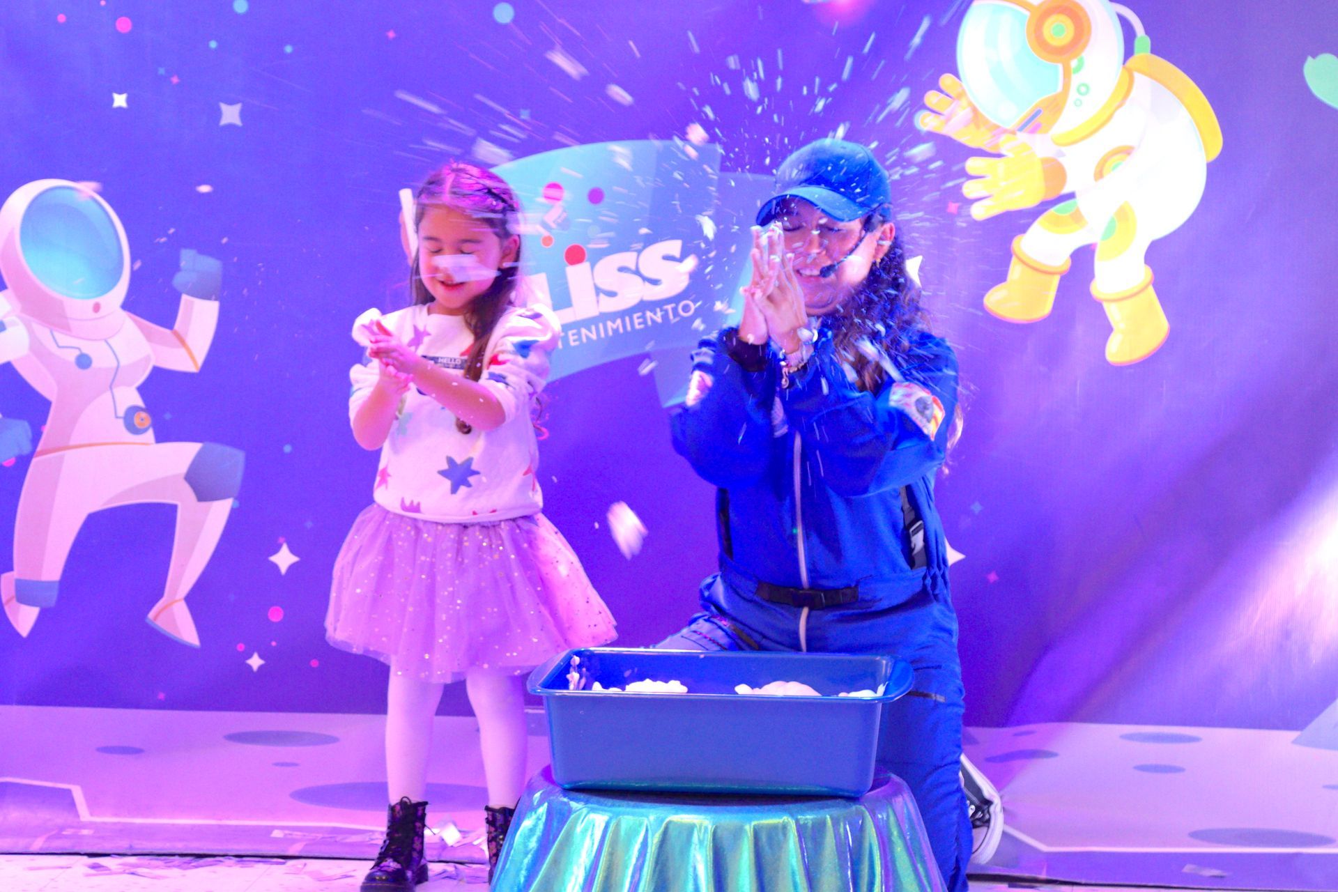 Un hombre y una niña están de pie en un escenario.