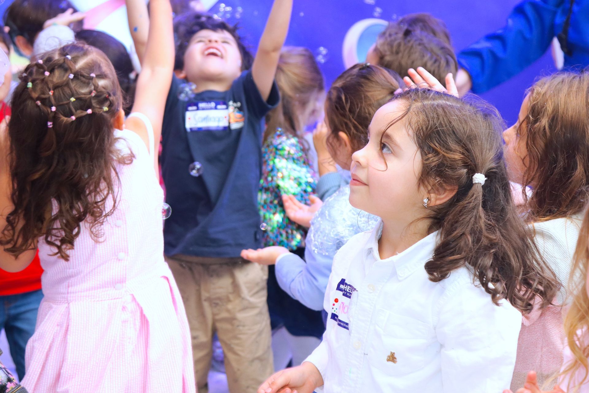 Un grupo de niños está jugando con burbujas en una fiesta.