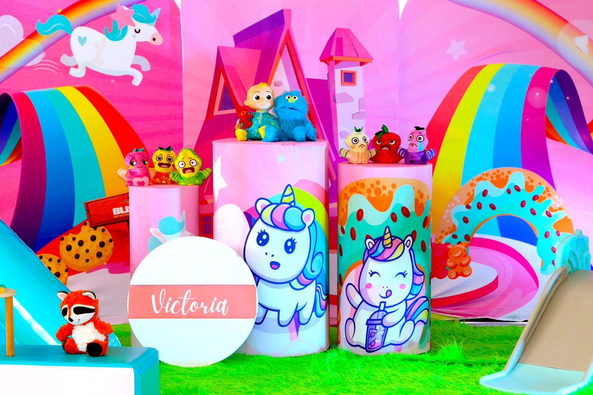 Una fiesta de cumpleaños con temática de unicornio con un castillo y un tobogán.