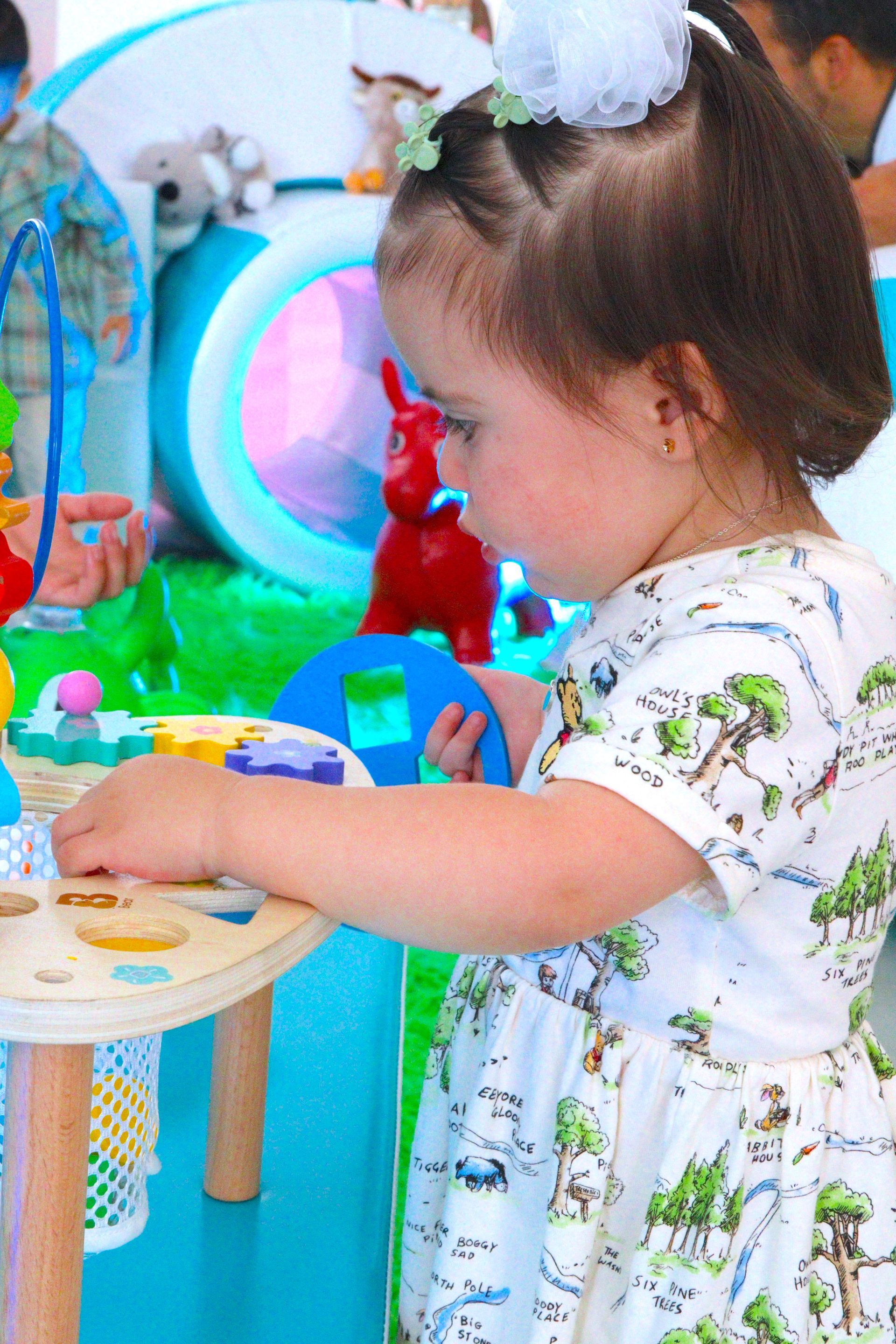 Una niña está jugando con juguetes en una mesa.