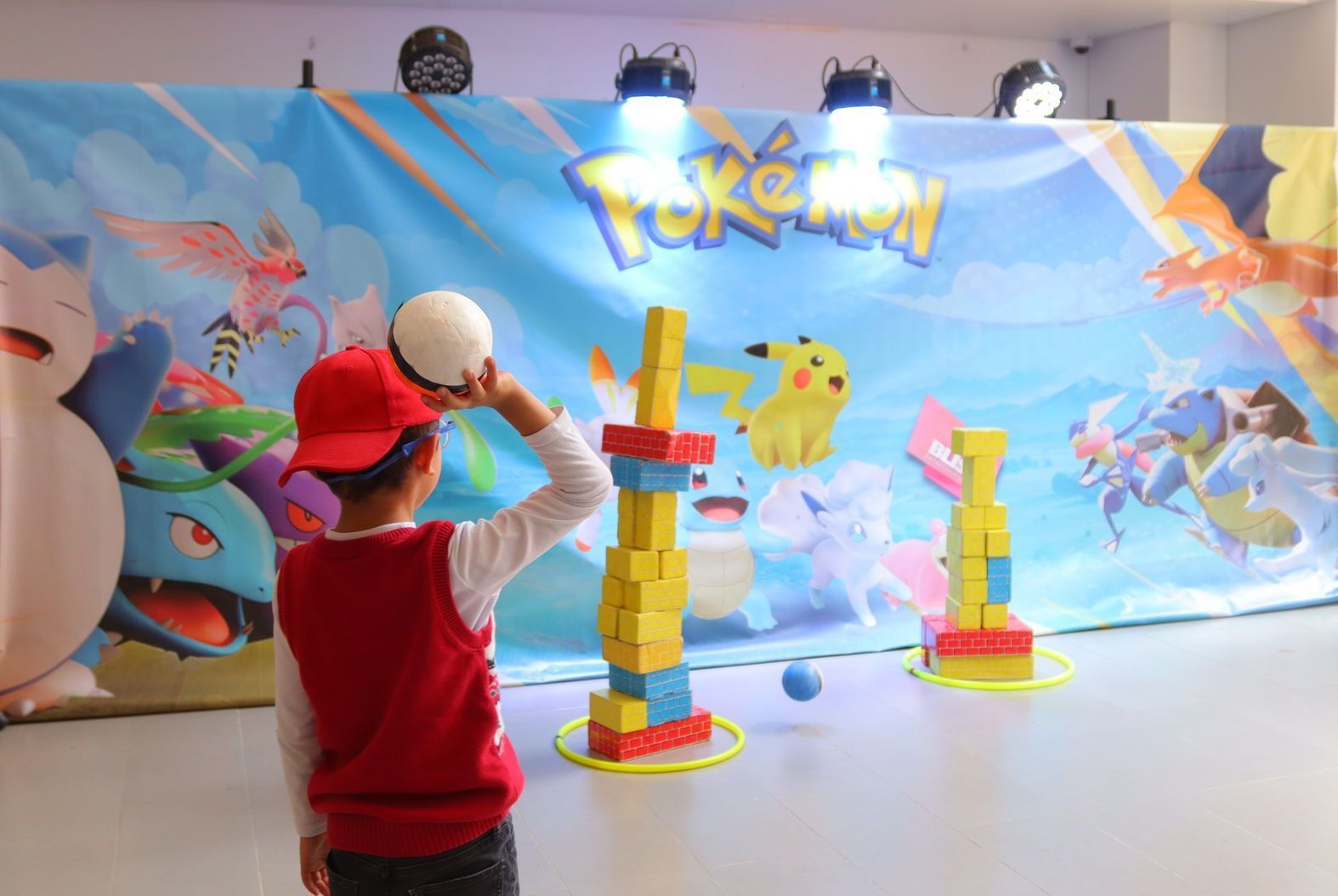 Un niño pequeño está jugando una partida de jenga frente a una pared de Pokémon.
