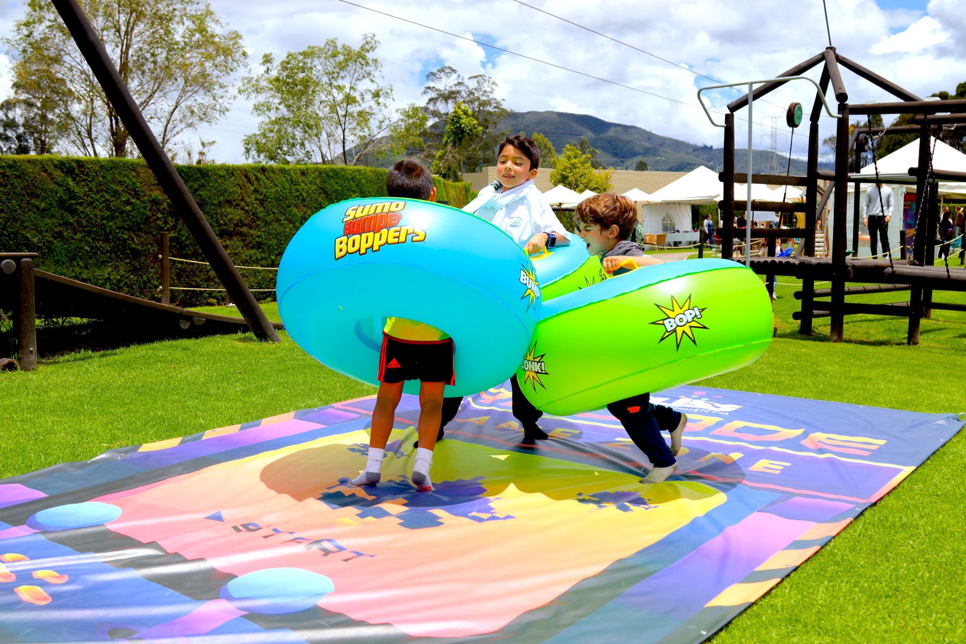 Un grupo de niños está jugando con pelotas inflables gigantes en un parque.