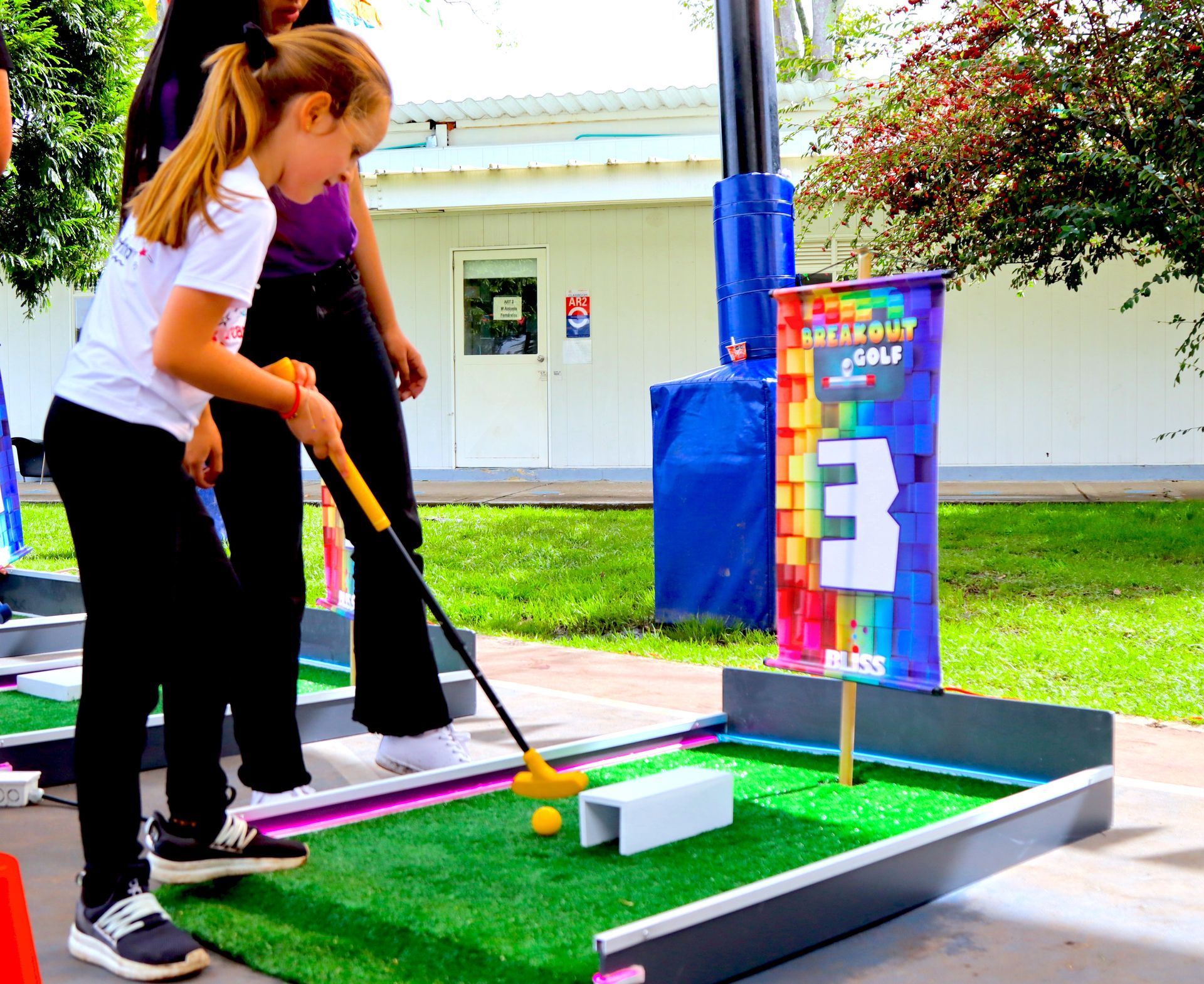Una niña está jugando un partido de minigolf