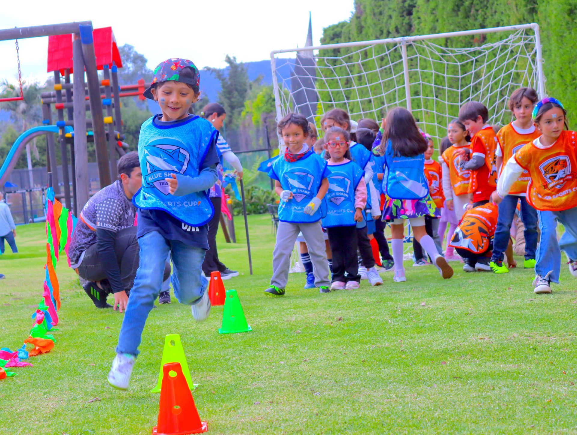 Un grupo de niños corre alrededor de un campo con conos.