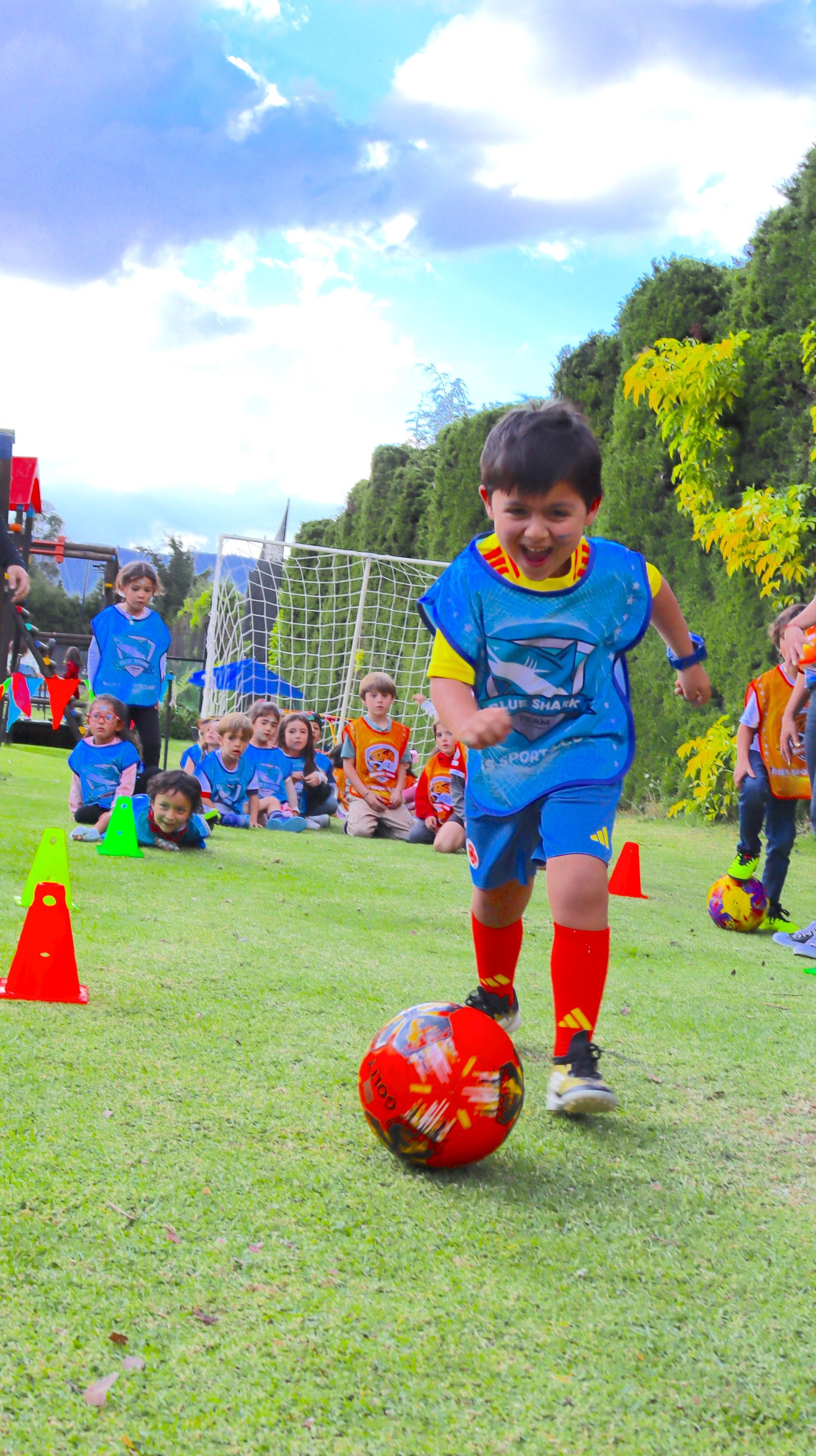 Un niño pequeño está pateando una pelota de fútbol en un campo.