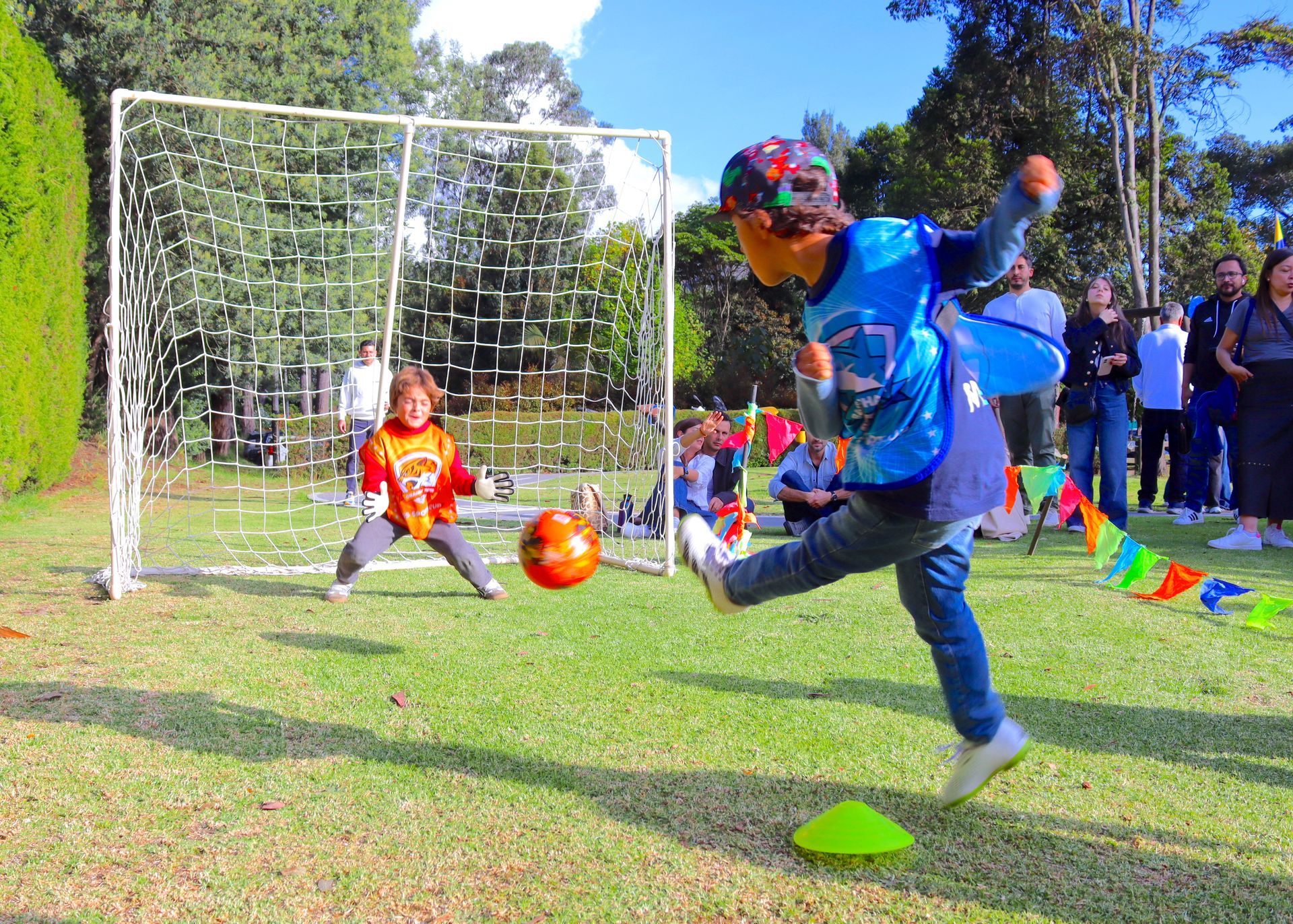 Un niño pequeño está pateando una pelota de fútbol en un campo.