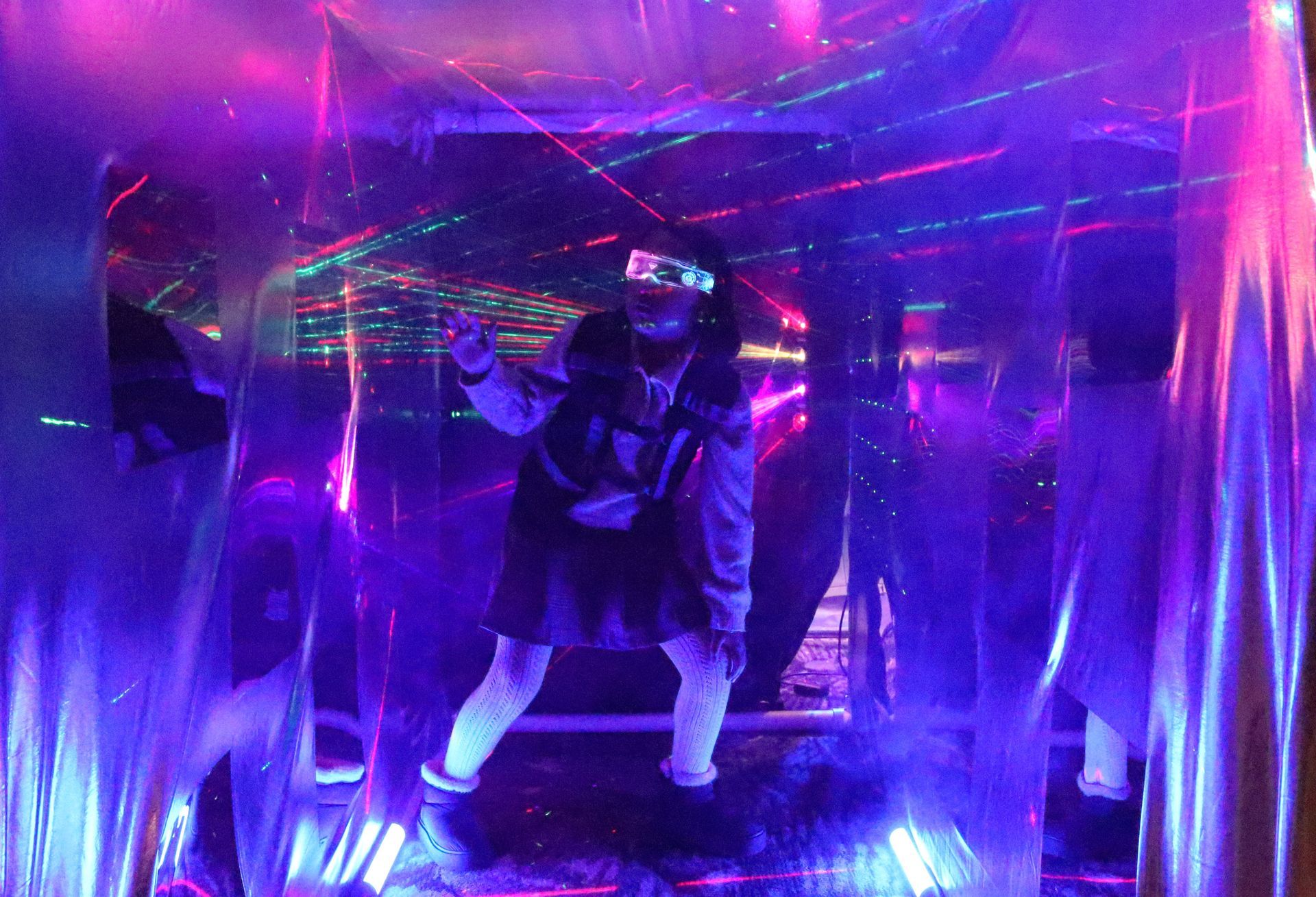 Una persona está bailando en una habitación con luces moradas.