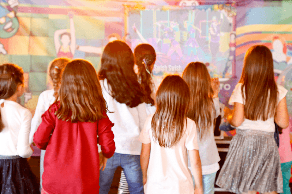 Un grupo de chicas jóvenes están bailando en una habitación en una fiesta.
