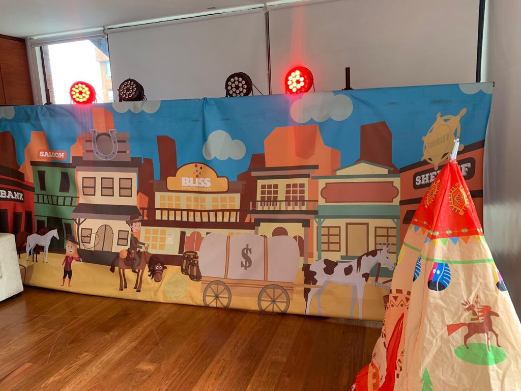 Hay un tipi frente a una pared con una imagen de un pueblo del oeste en ella.