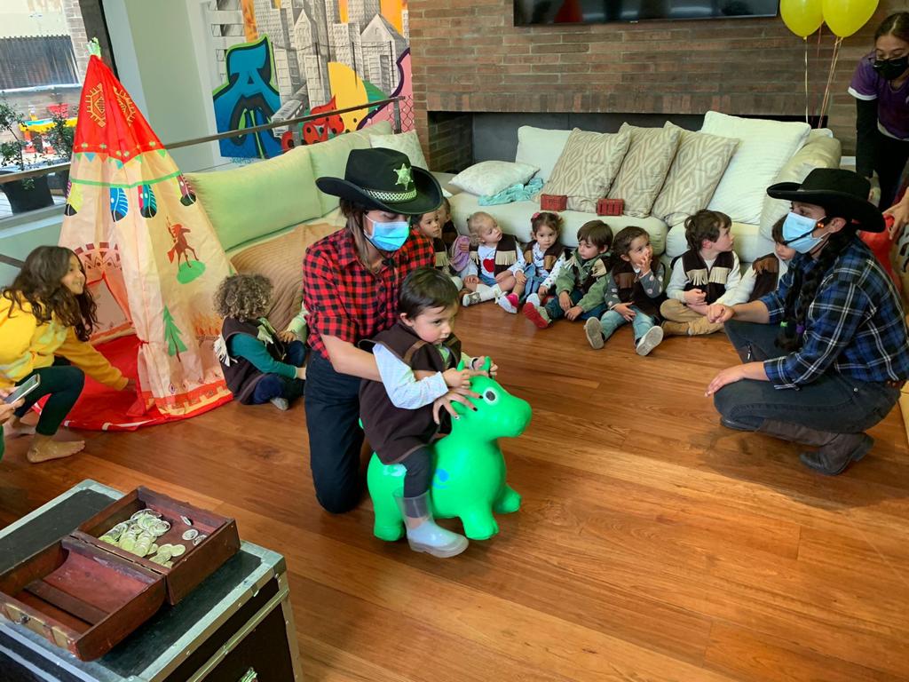 Un grupo de niños está jugando con un caballo de juguete en una sala de estar.