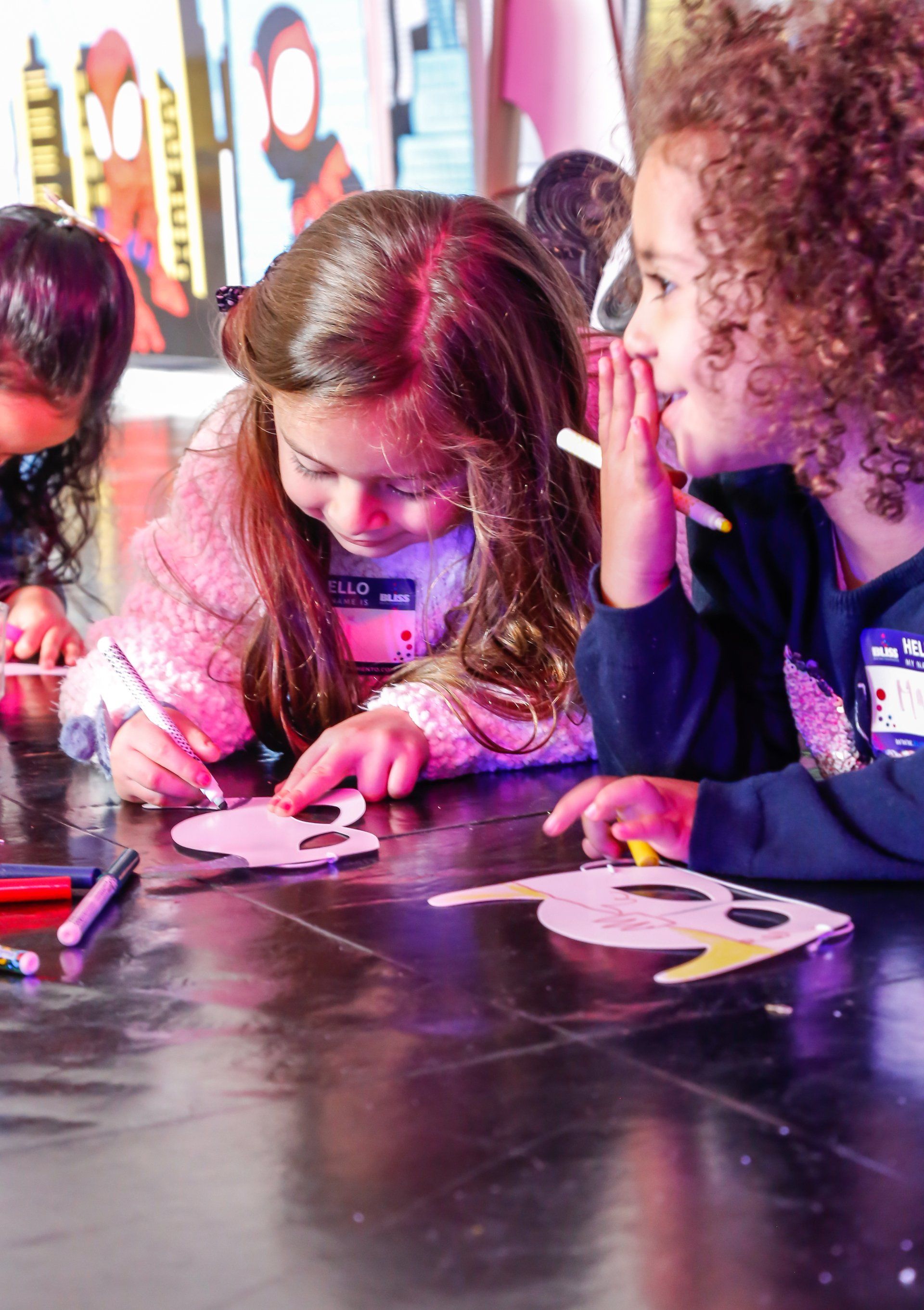 Un grupo de niños está sentado en una mesa dibujando en un trozo de papel.