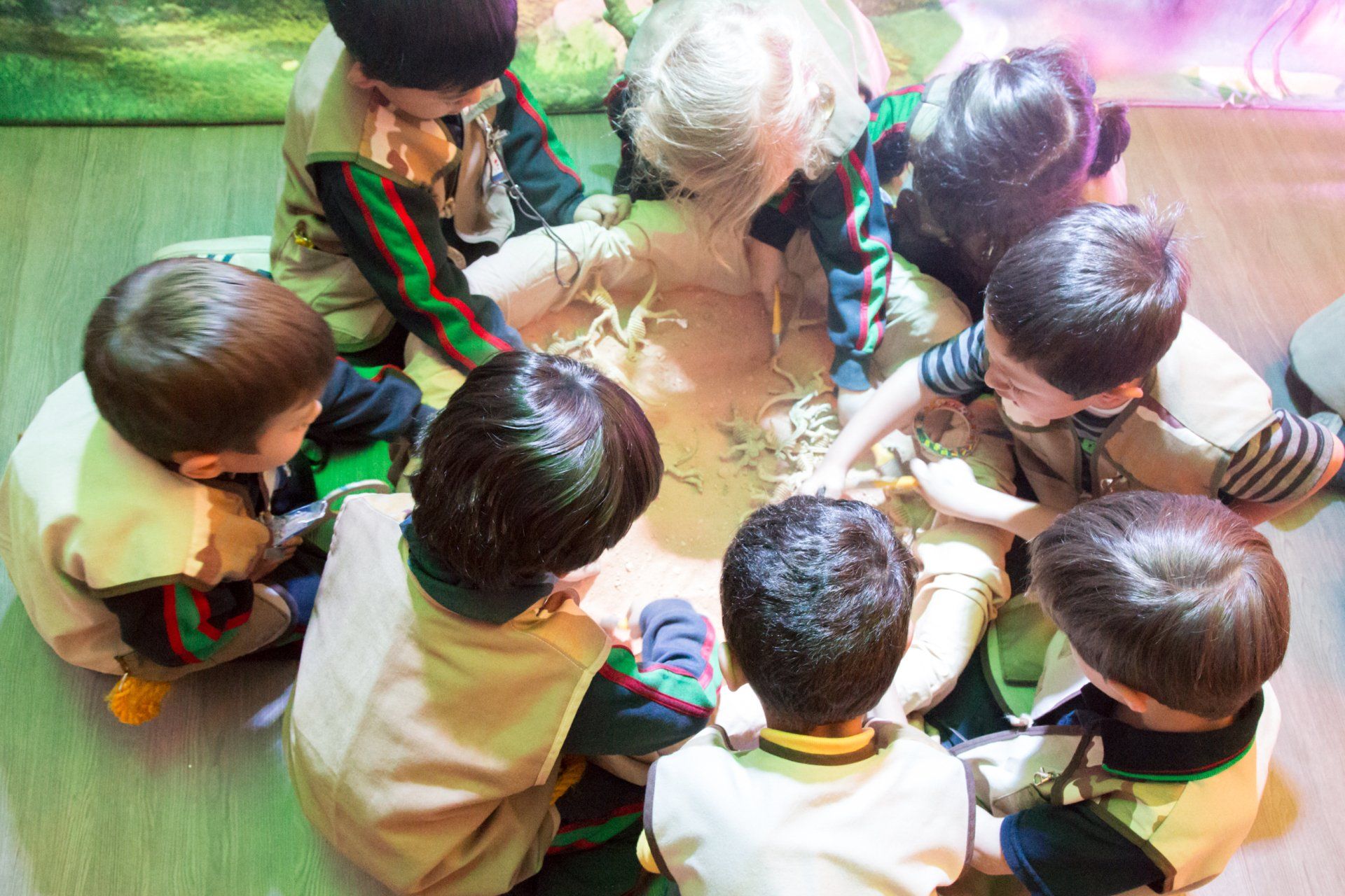 Un grupo de niños está sentado en círculo en el suelo.