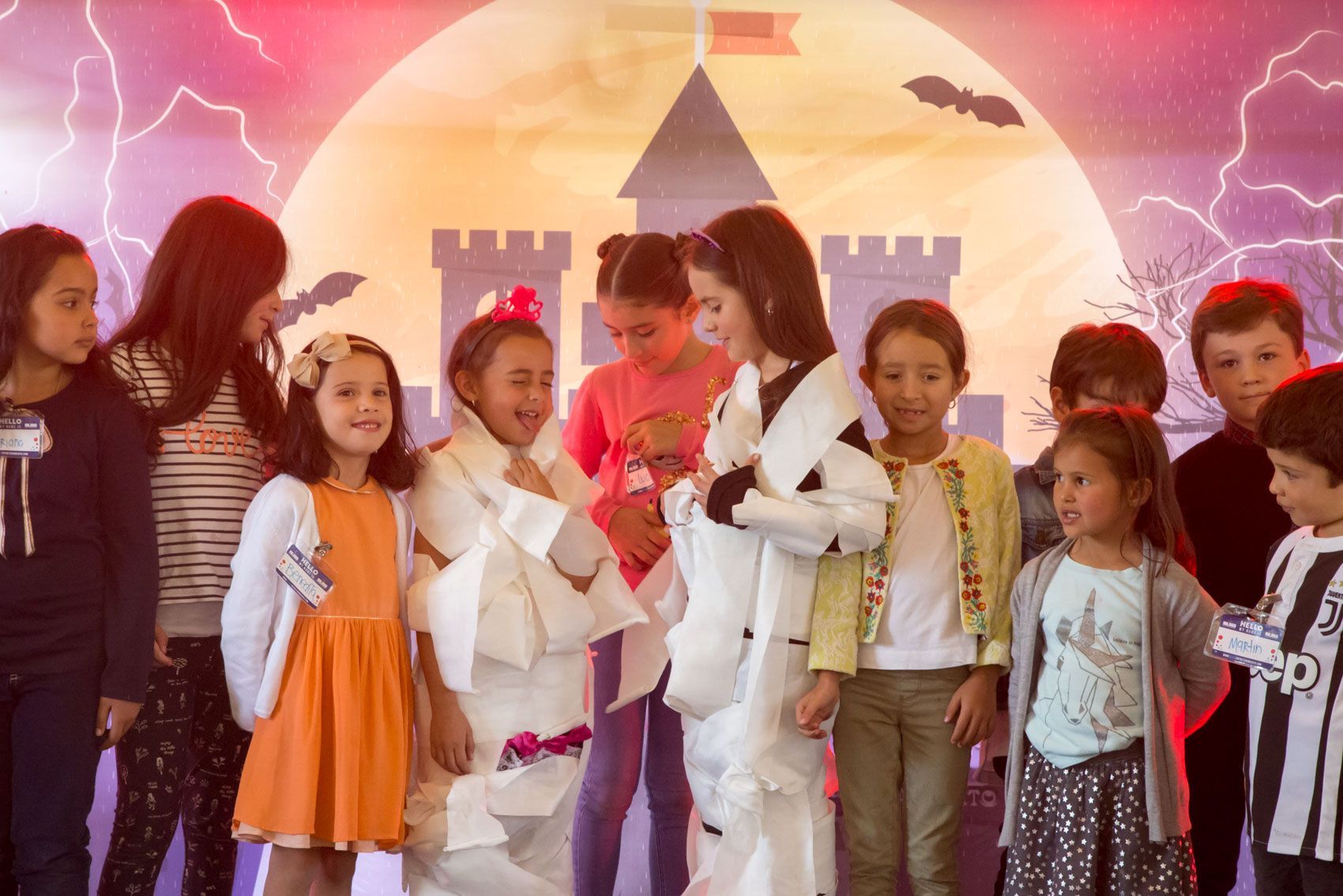 Un grupo de niños están parados uno al lado del otro frente a un castillo.