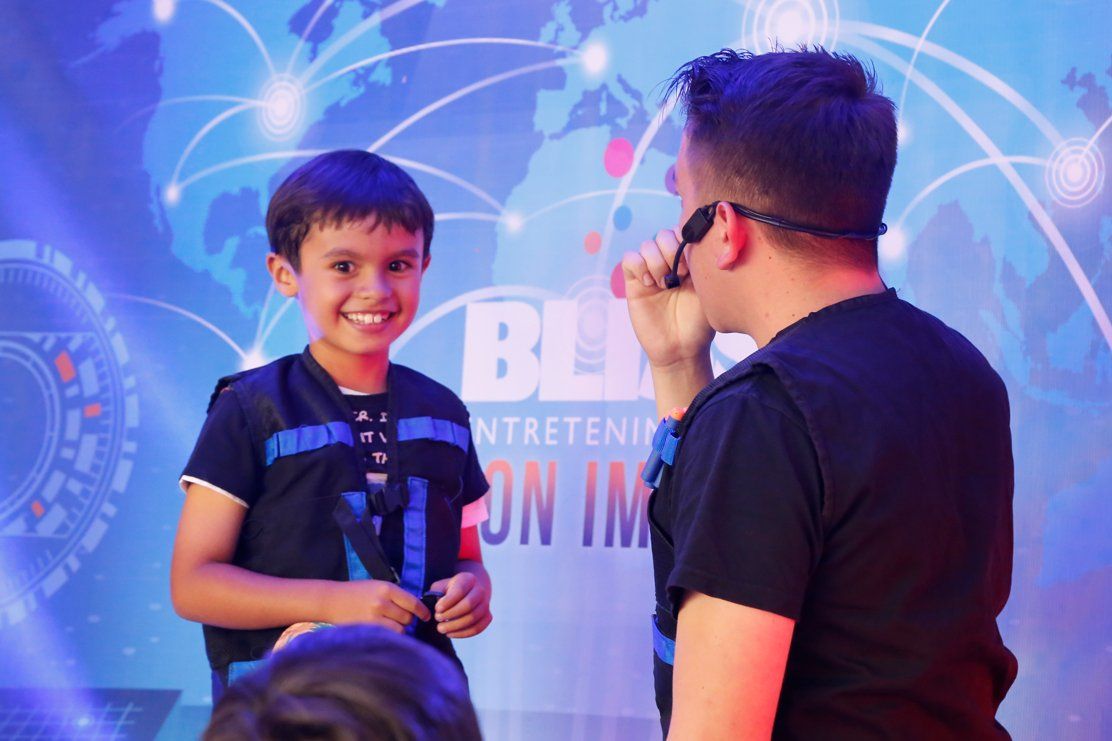 Un hombre habla a través de un micrófono al lado de un niño pequeño.