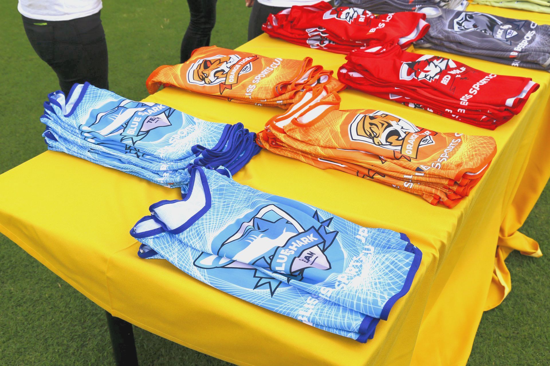 Una mesa amarilla con un montón de camisas encima.