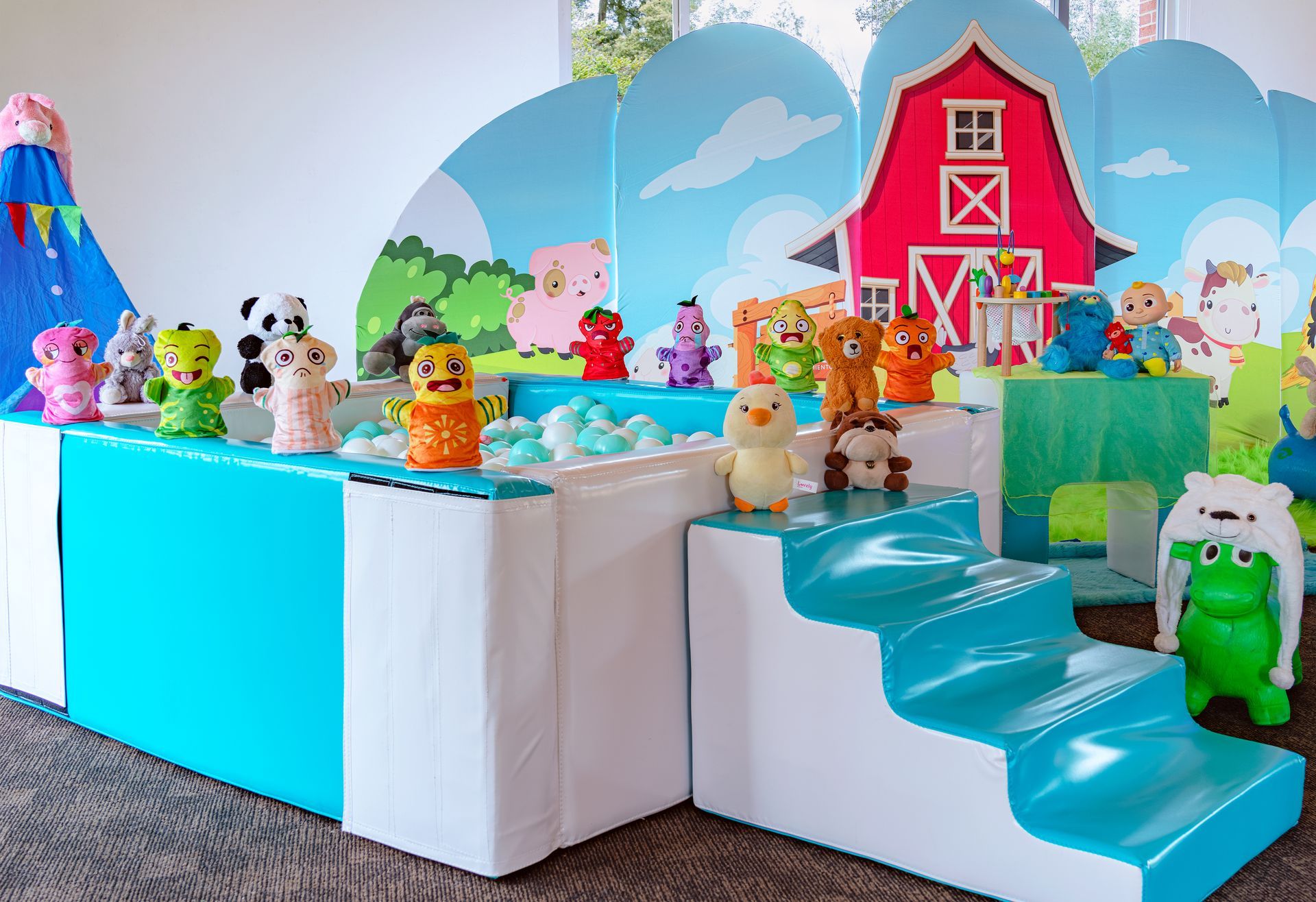 Una habitación llena de muchos animales de peluche y un granero rojo.