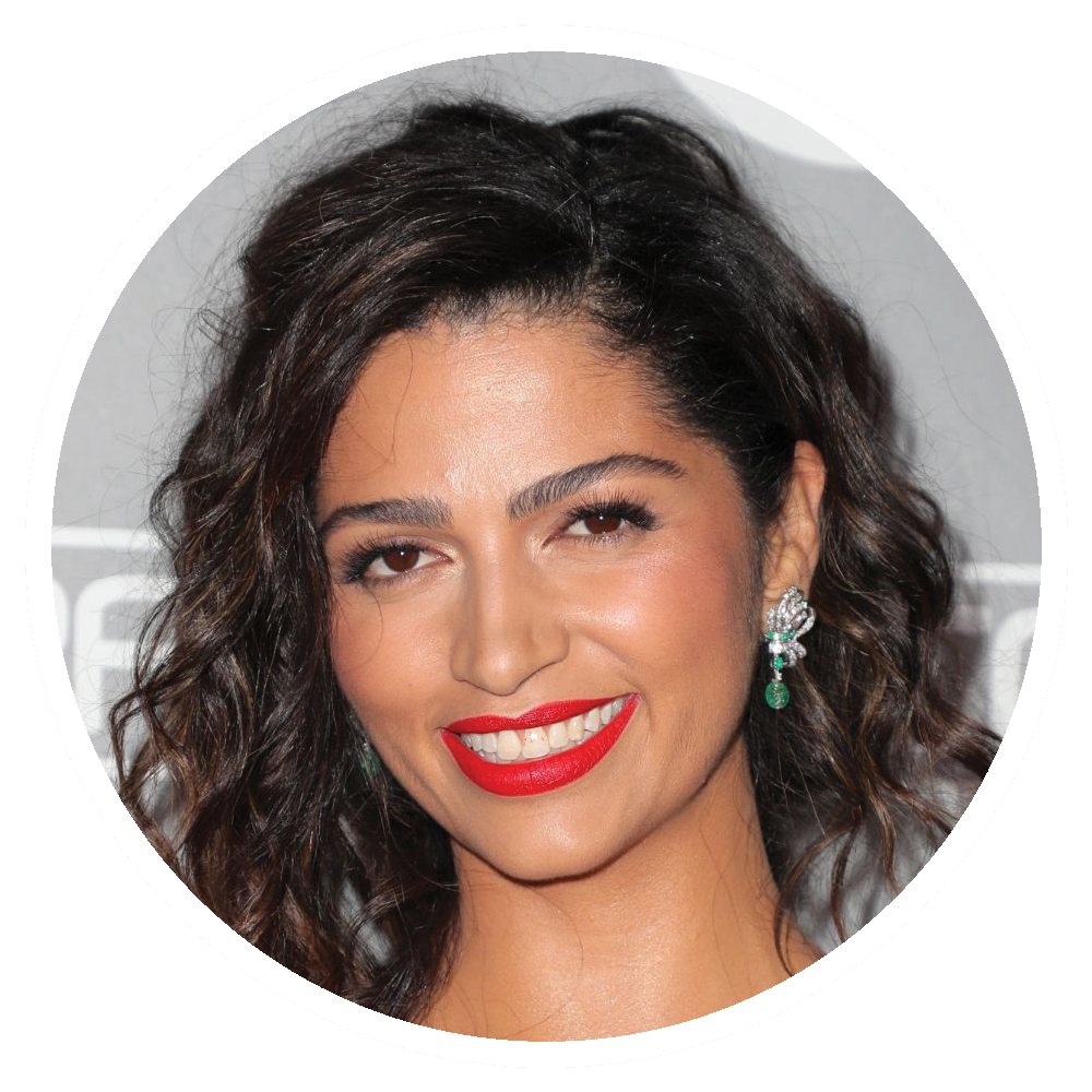 Camila Alves with dark hair, red lipstick, and an ear piercing with a flower-shaped earring.