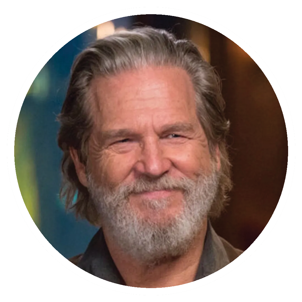 Jeff Bridges smiles with a gray beard and hair.
