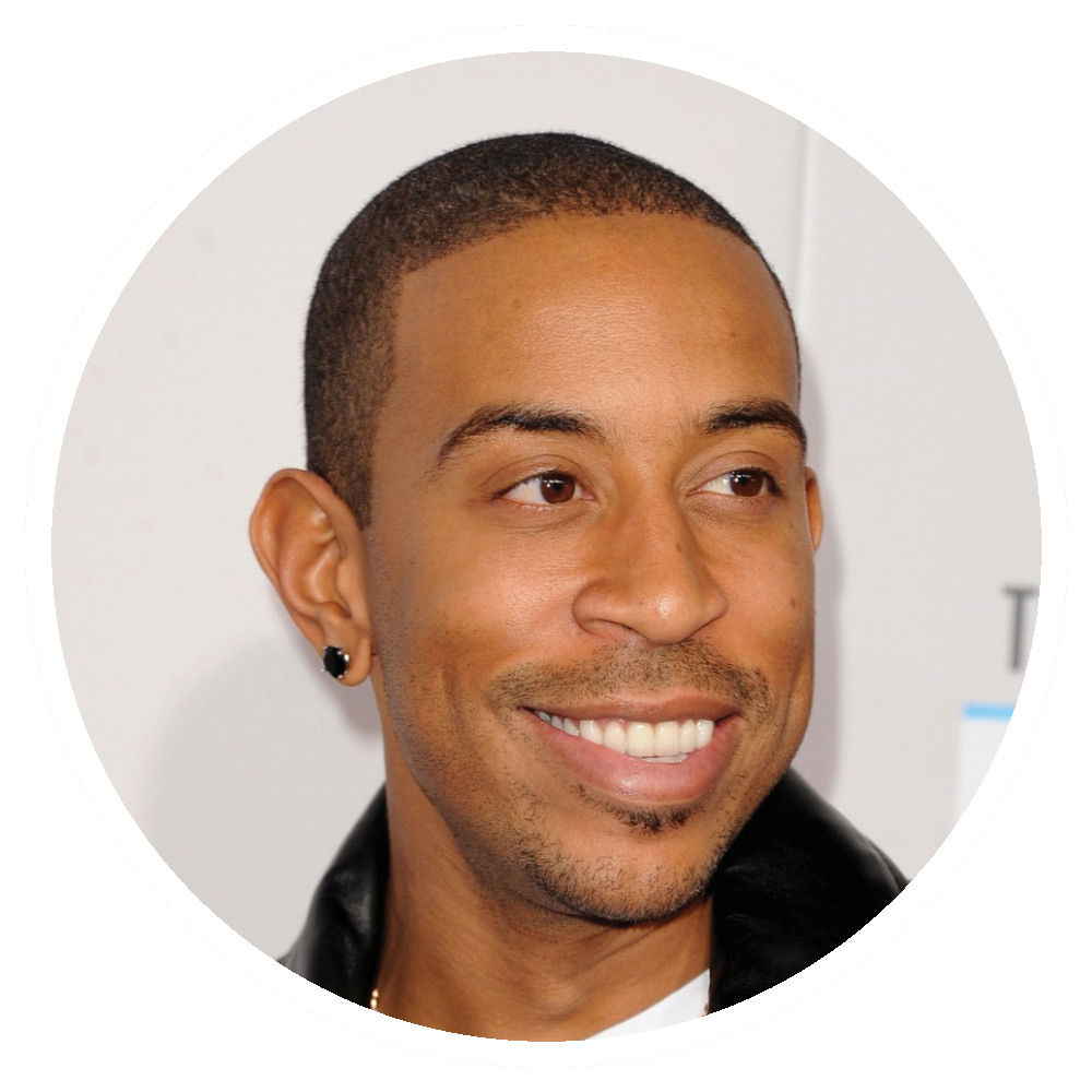 Ludacris smiling, looking right, wearing a black leather jacket.