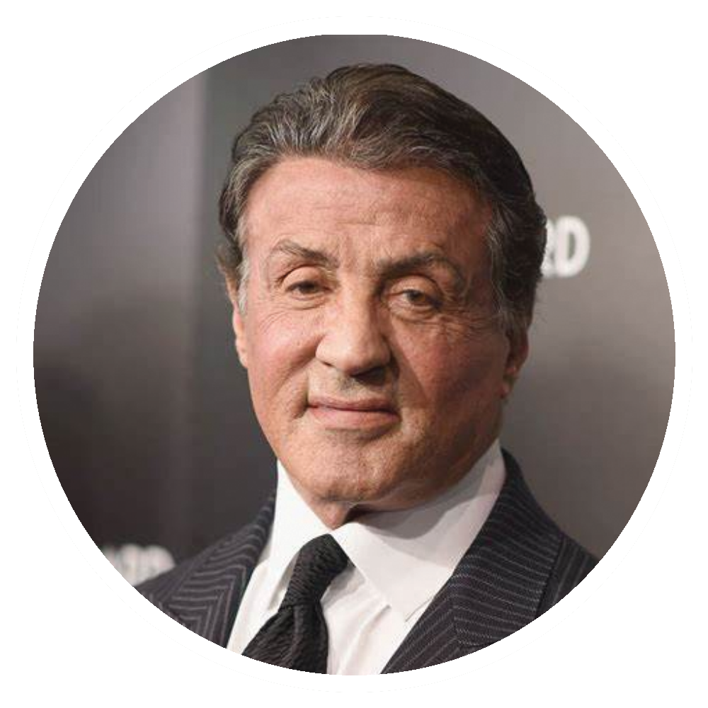 Sylvester Stallone in a suit, smiling at the camera.