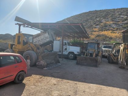 Minicargador cargando material en patio de obra