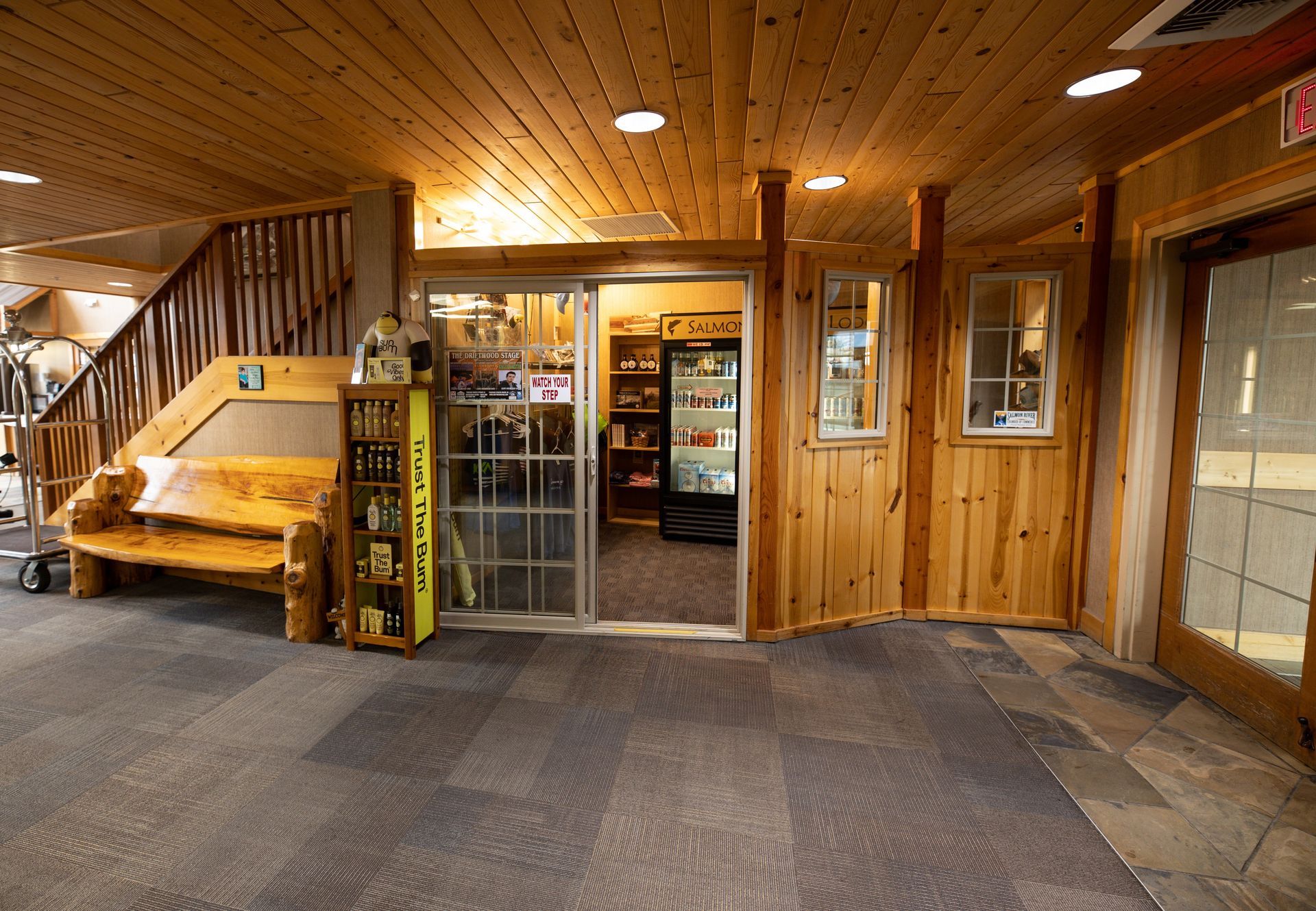 A wooden building with a sliding glass door leading to a store
