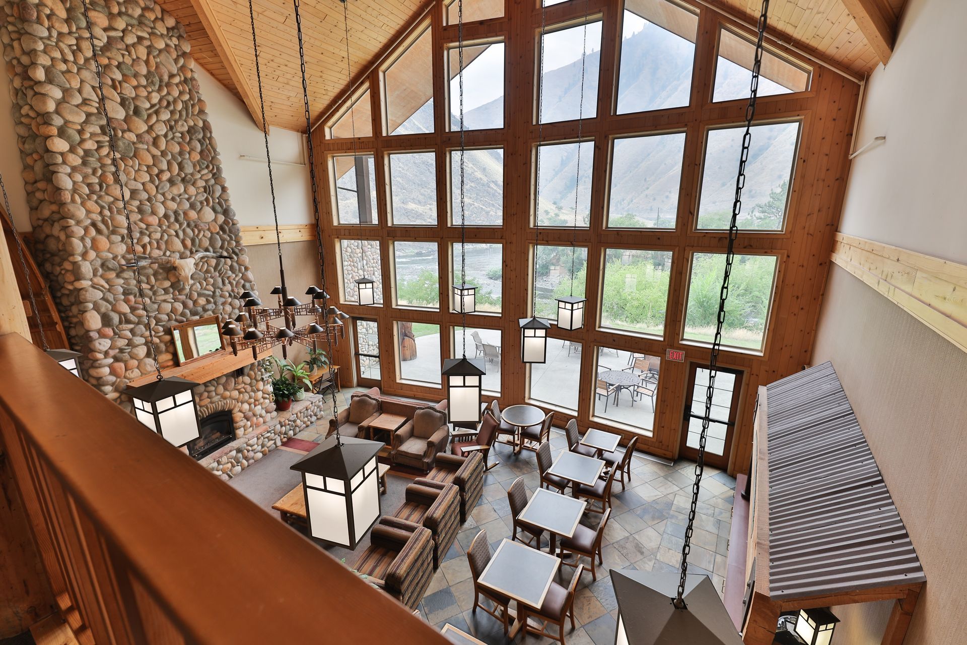 A large room with tables and chairs and a fireplace